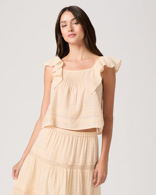 Model wearing a light peach midi skirt paired with a light peach top and brown sandals