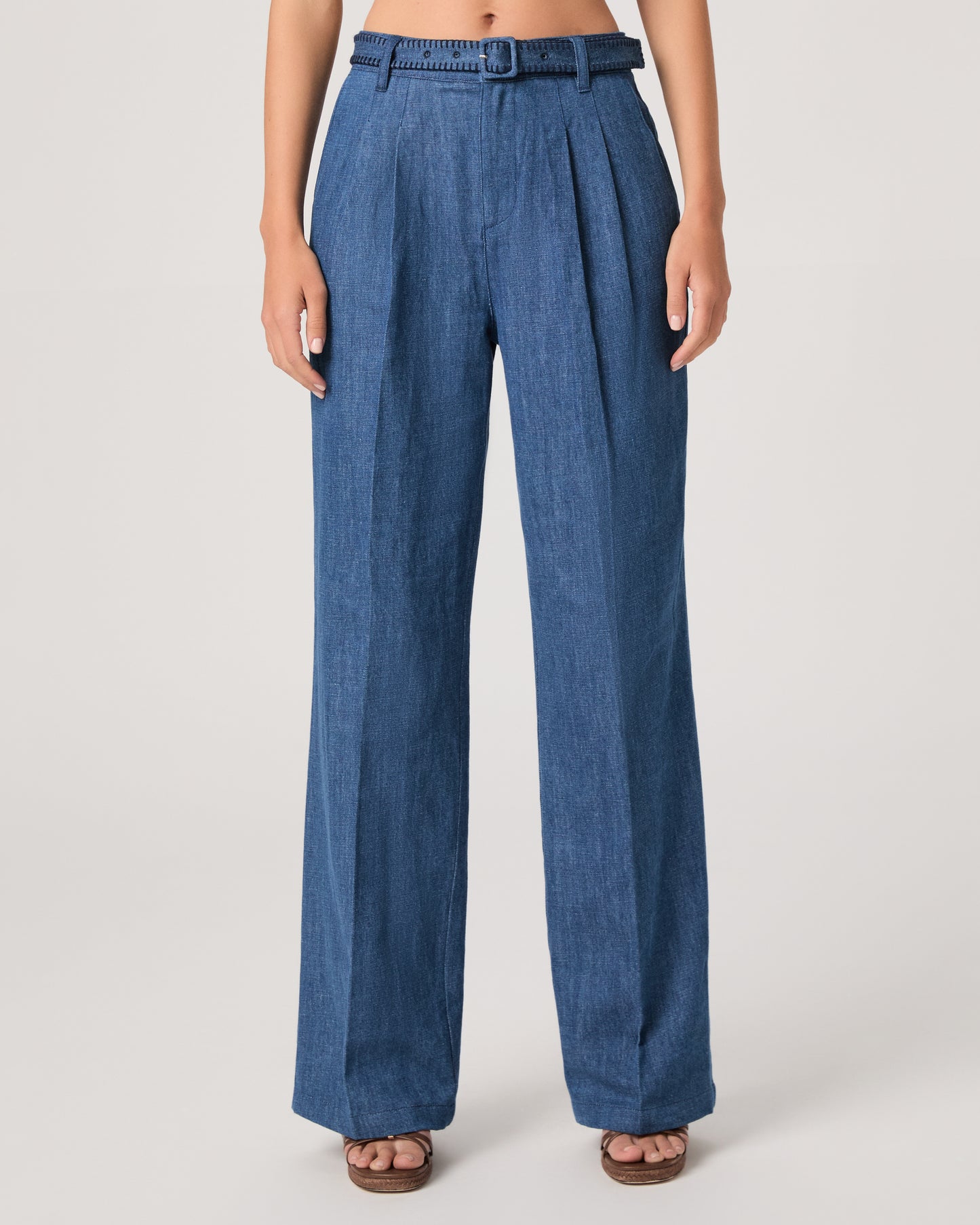 Woman wearing a denim top paired with matching denim pants on a white background