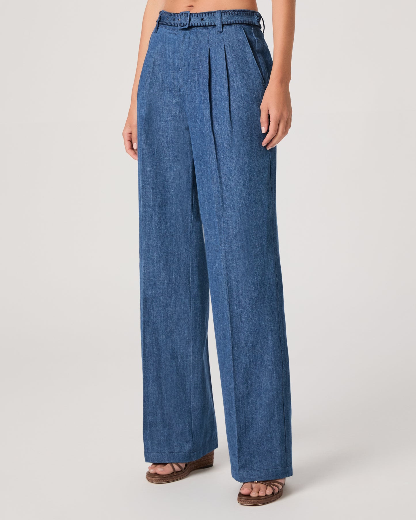 Woman wearing a denim top paired with matching denim pants on a white background