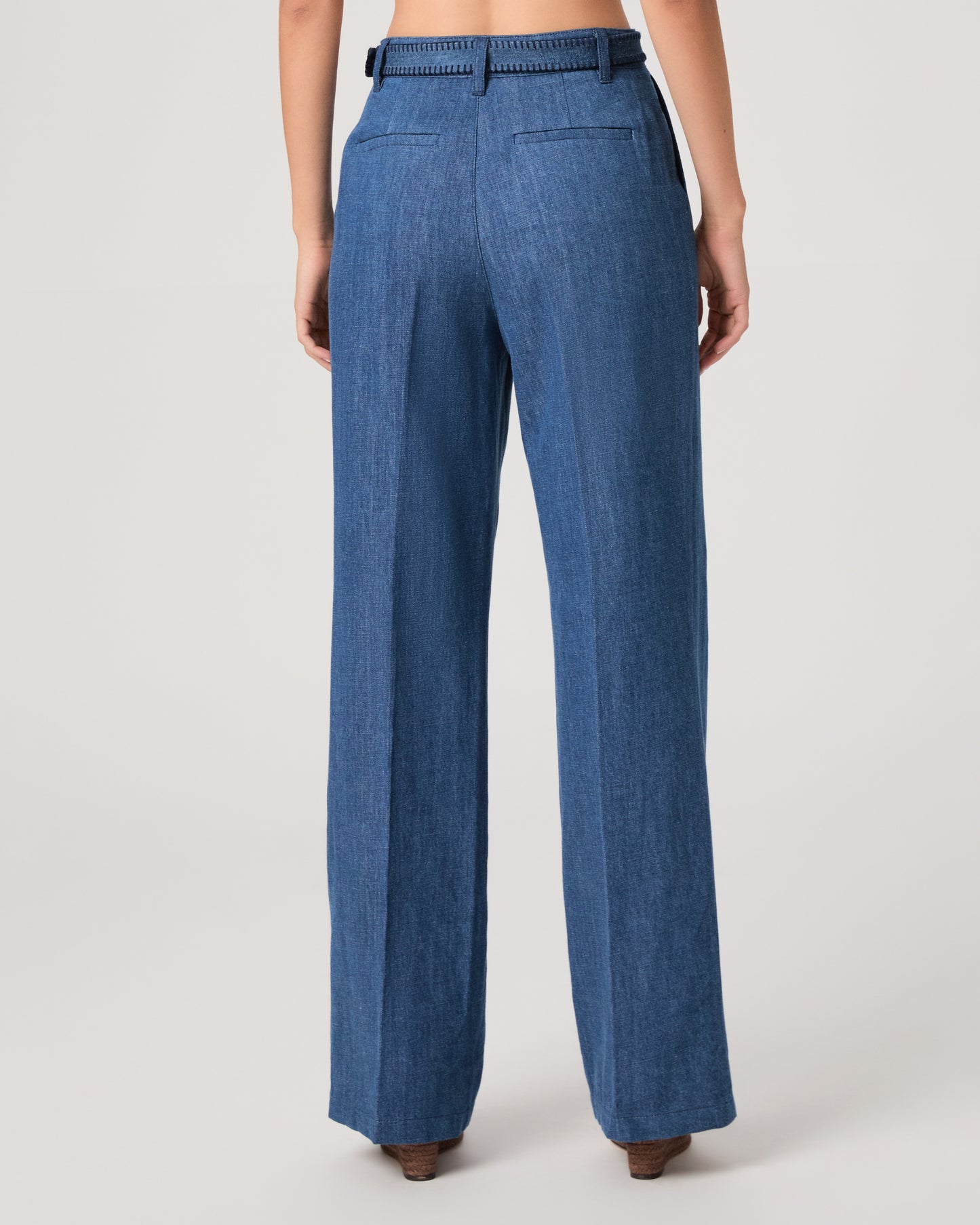 Woman wearing a denim top paired with matching denim pants on a white background