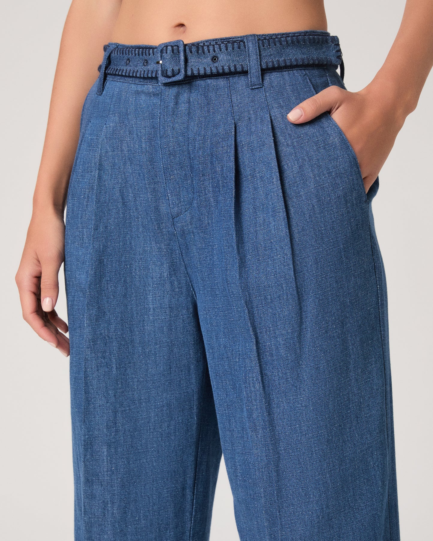 Woman wearing a denim top paired with matching denim pants on a white background