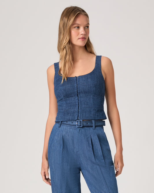 Woman wearing a denim top paired with matching denim pants on a white background