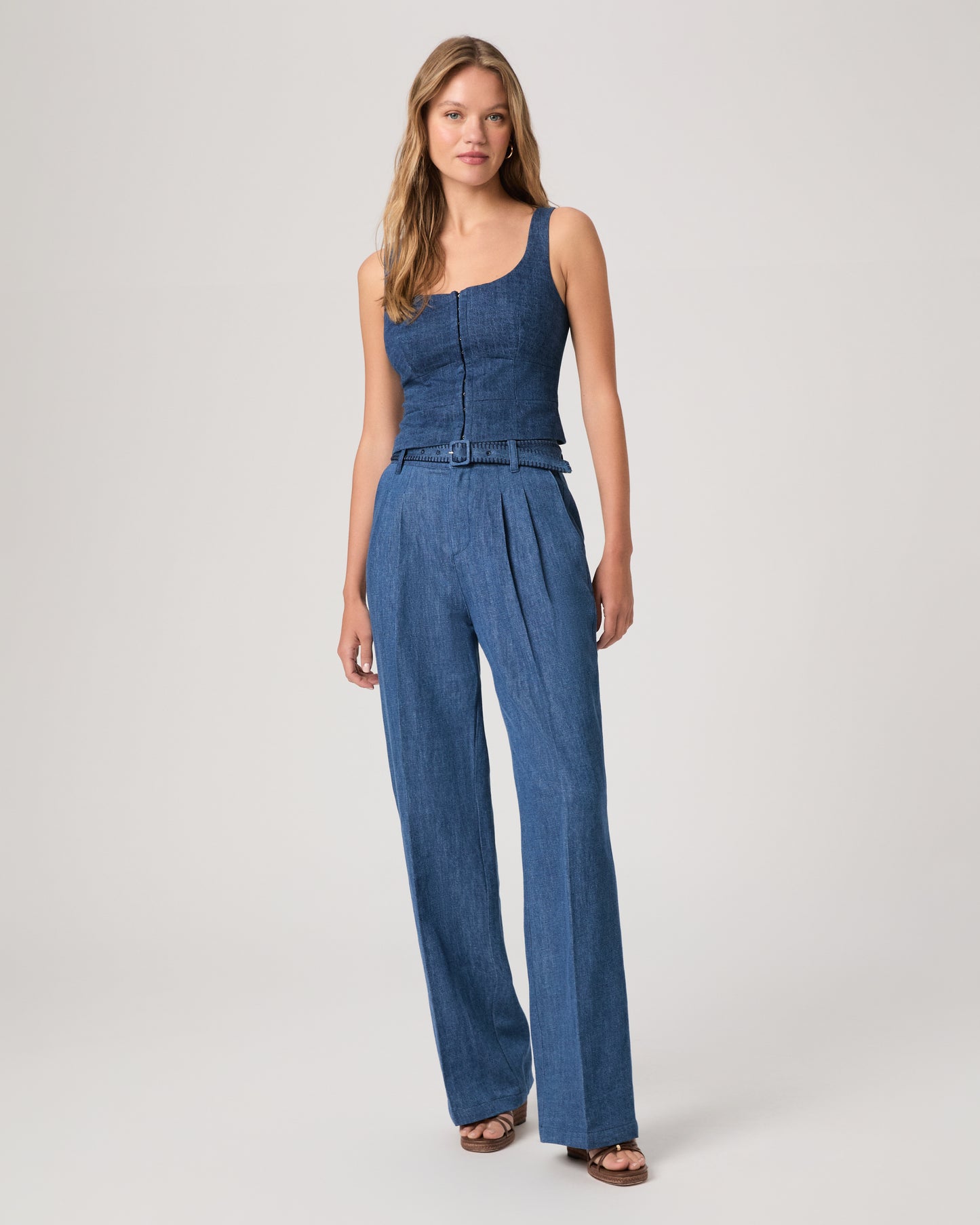Woman wearing a denim top paired with matching denim pants on a white background