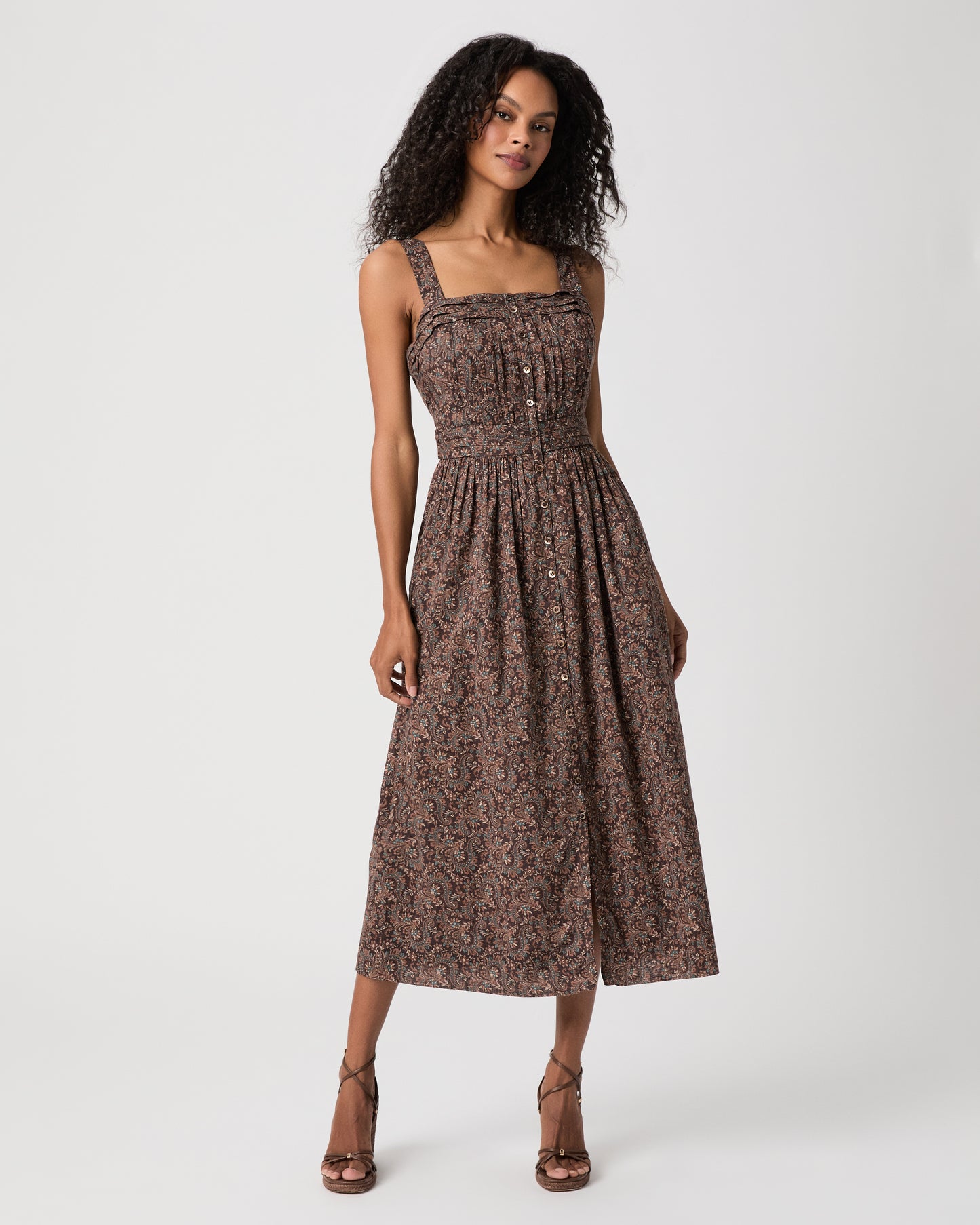 women wearing a brown midi print dress and brown heels against a white background 