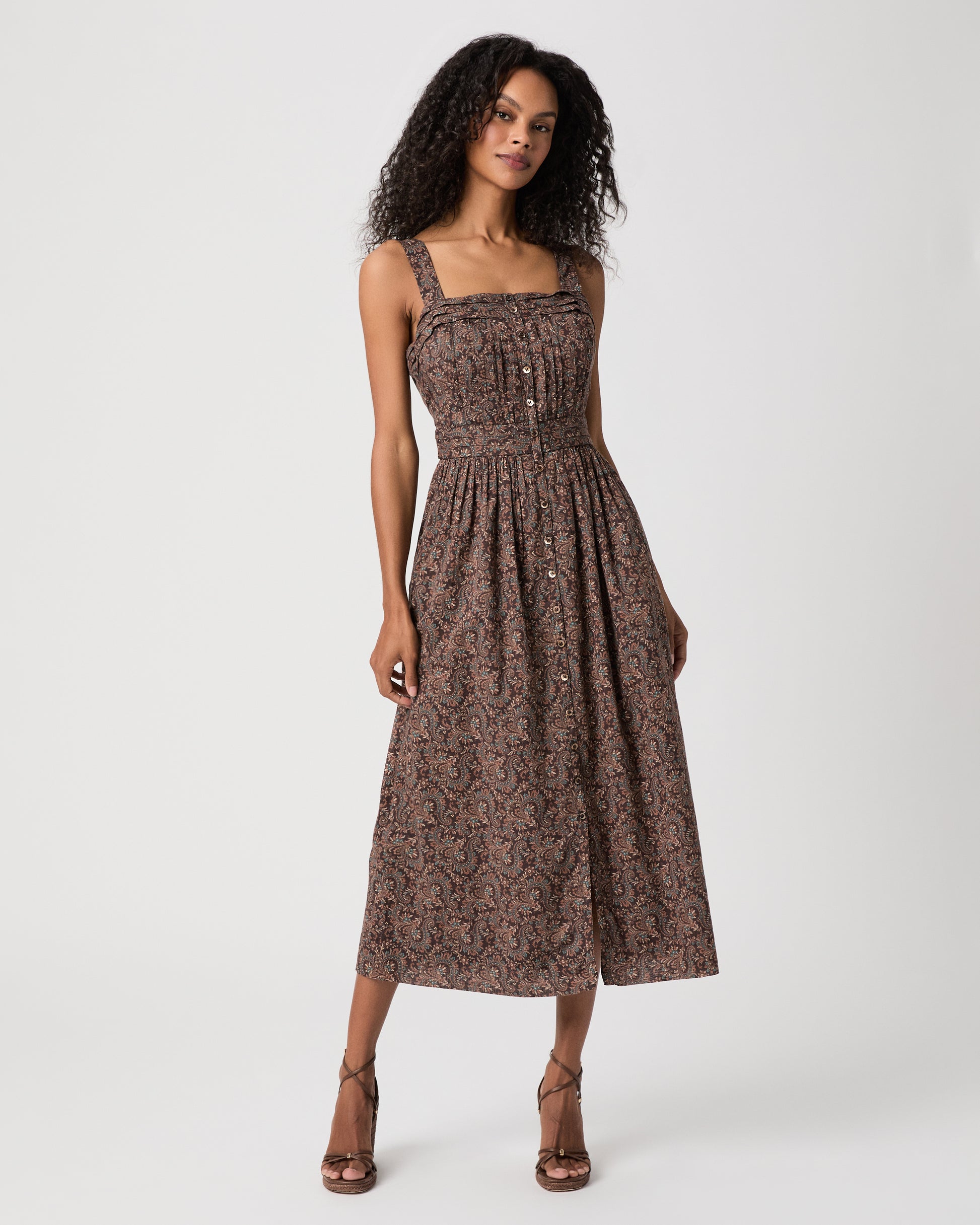 women wearing a brown midi print dress and brown heels against a white background 
