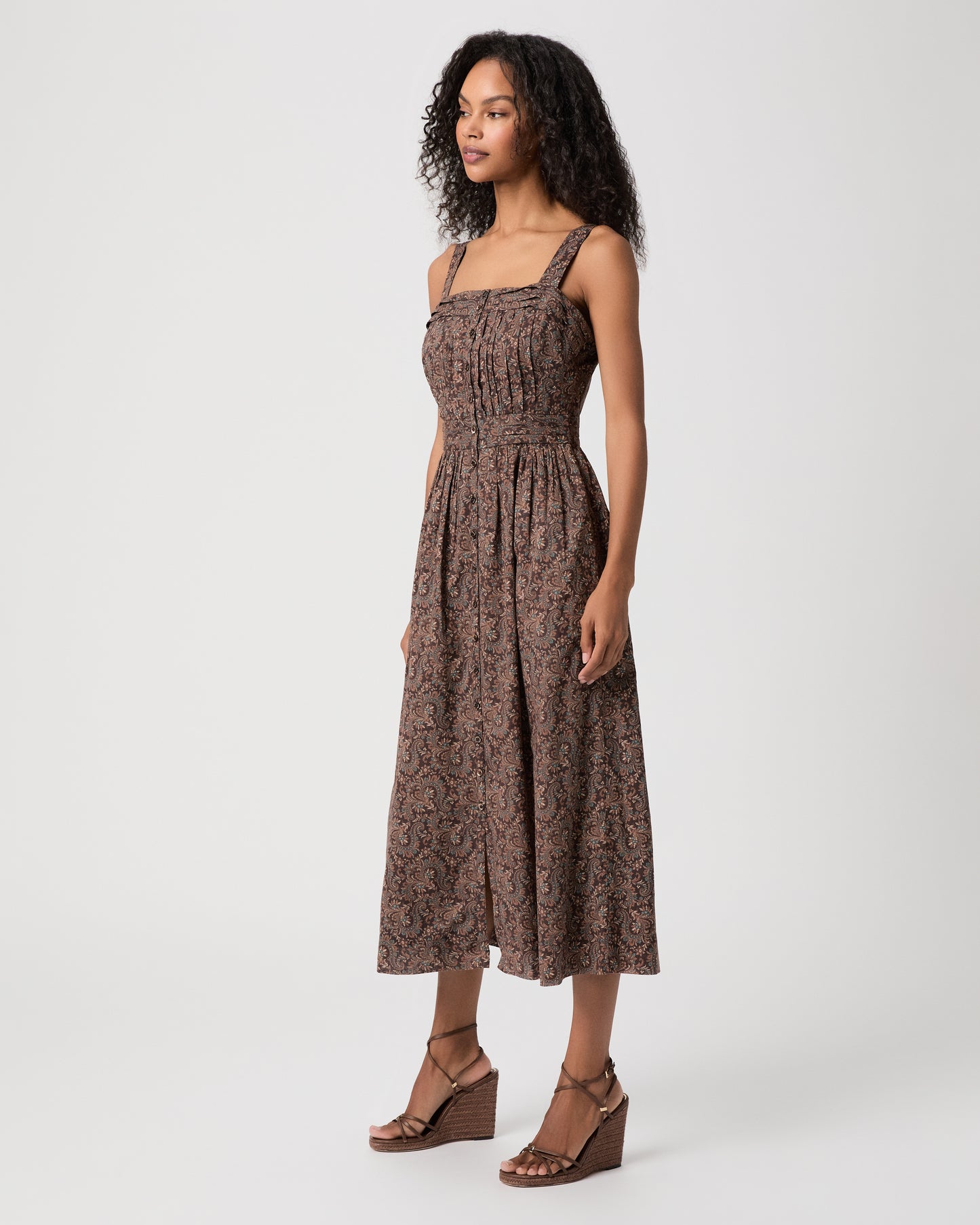 women wearing a brown midi print dress and brown heels against a white background 