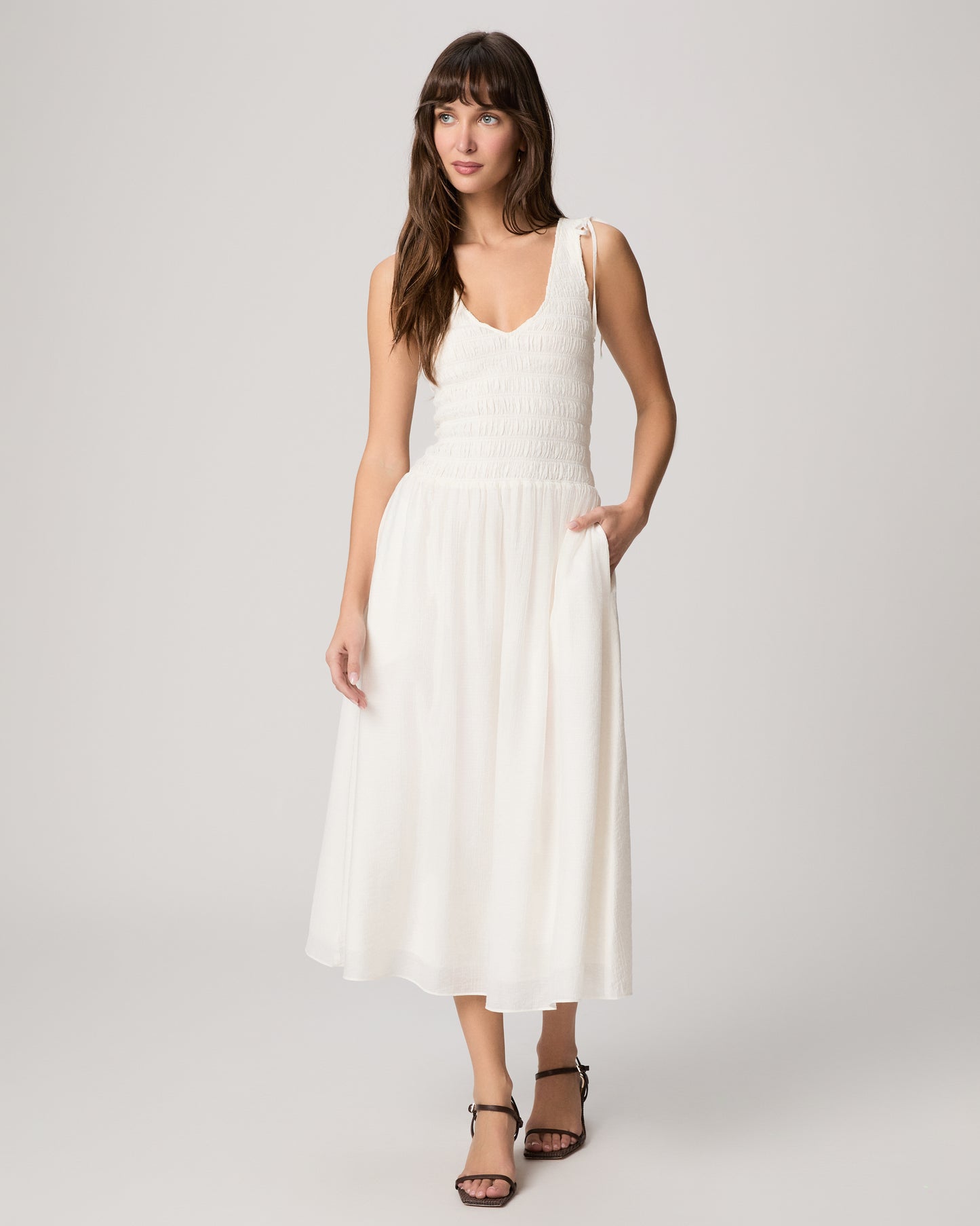 Woman wearing a white dress against a white background