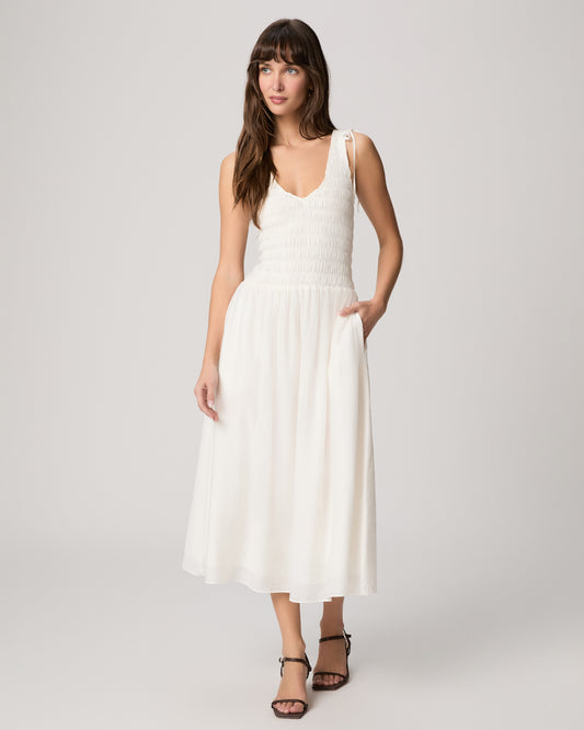 Woman wearing a white dress against a white background