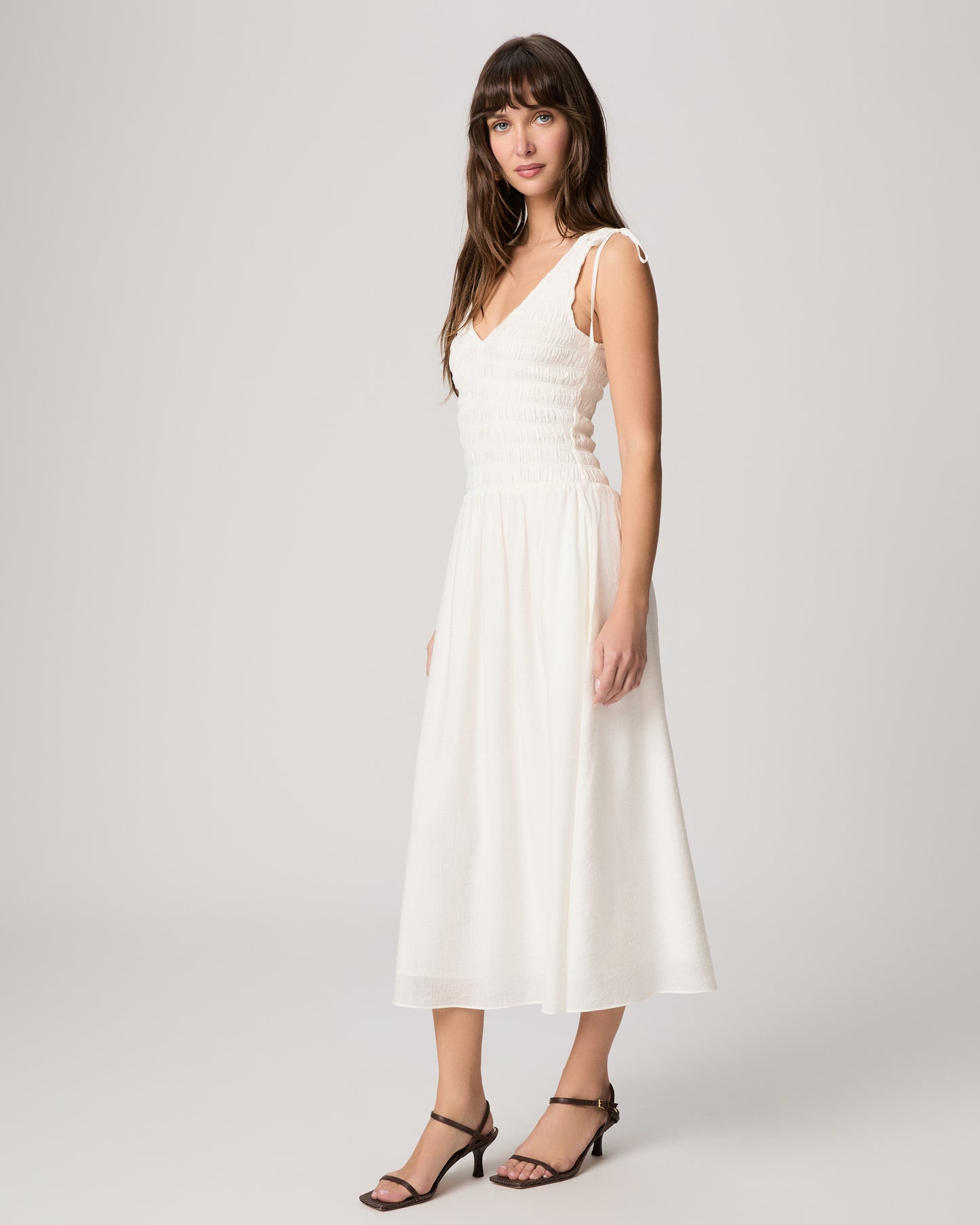Woman wearing a white dress against a white background