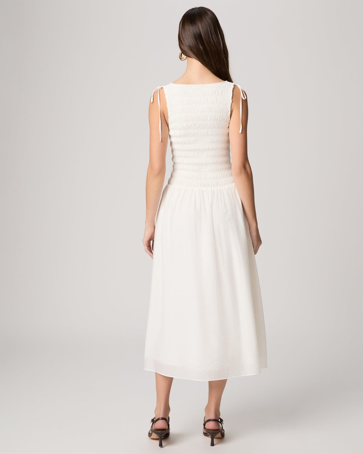 Woman wearing a white dress against a white background