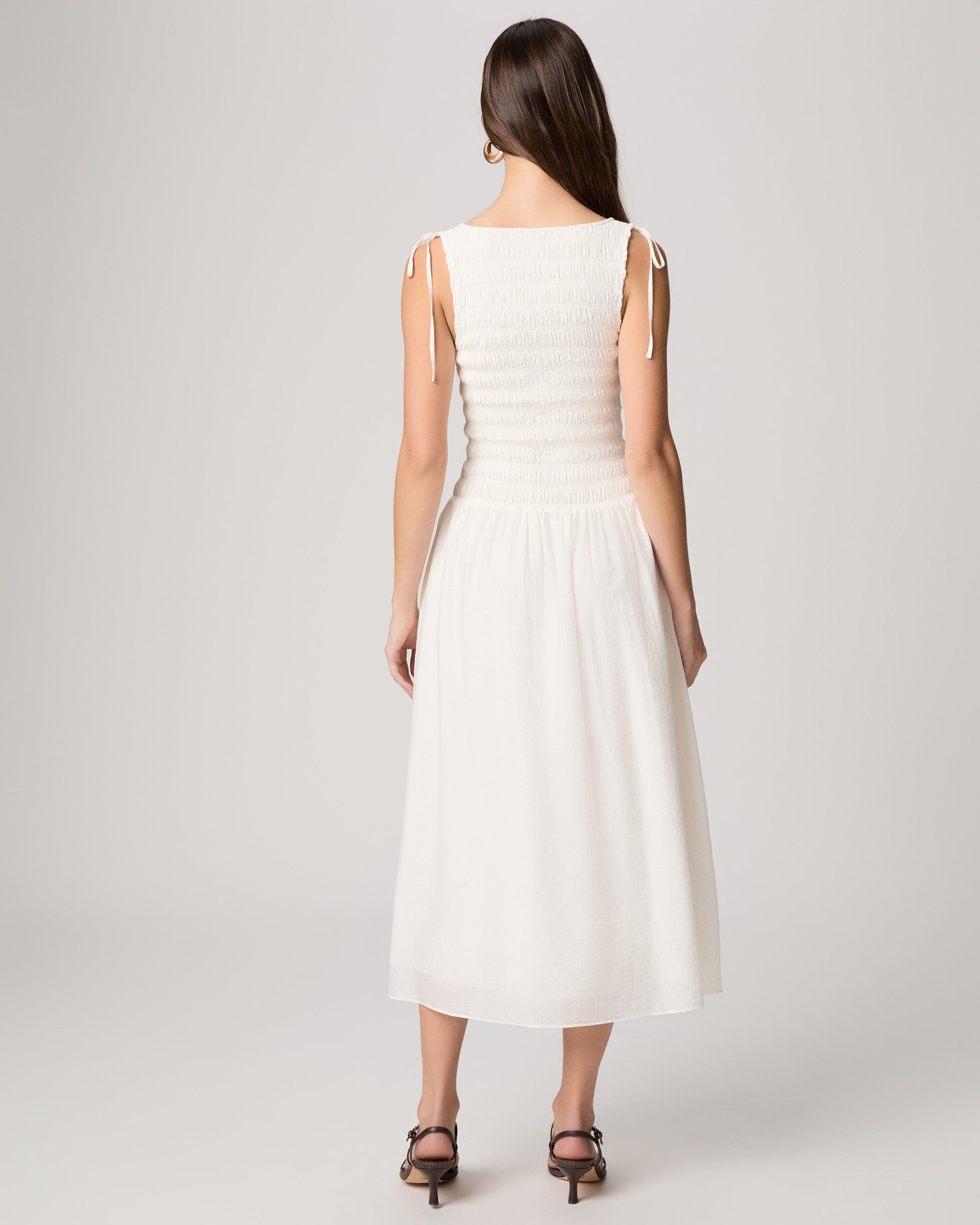 Woman wearing a white dress against a white background
