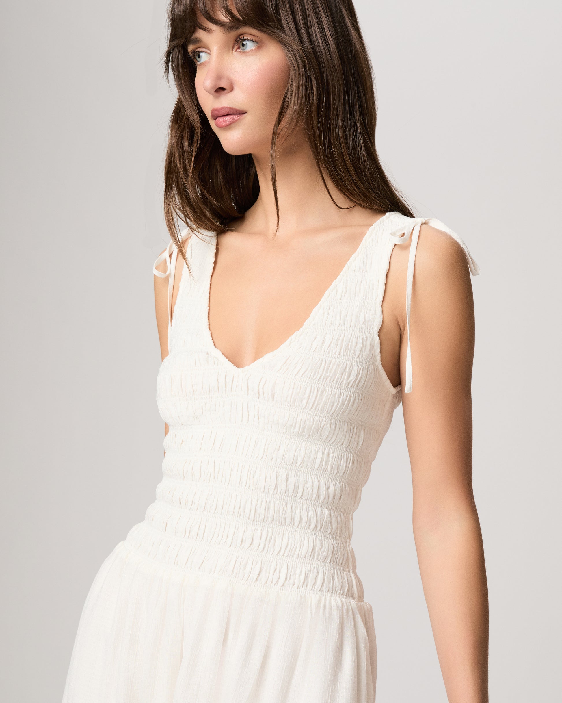 Woman wearing a white dress against a white background