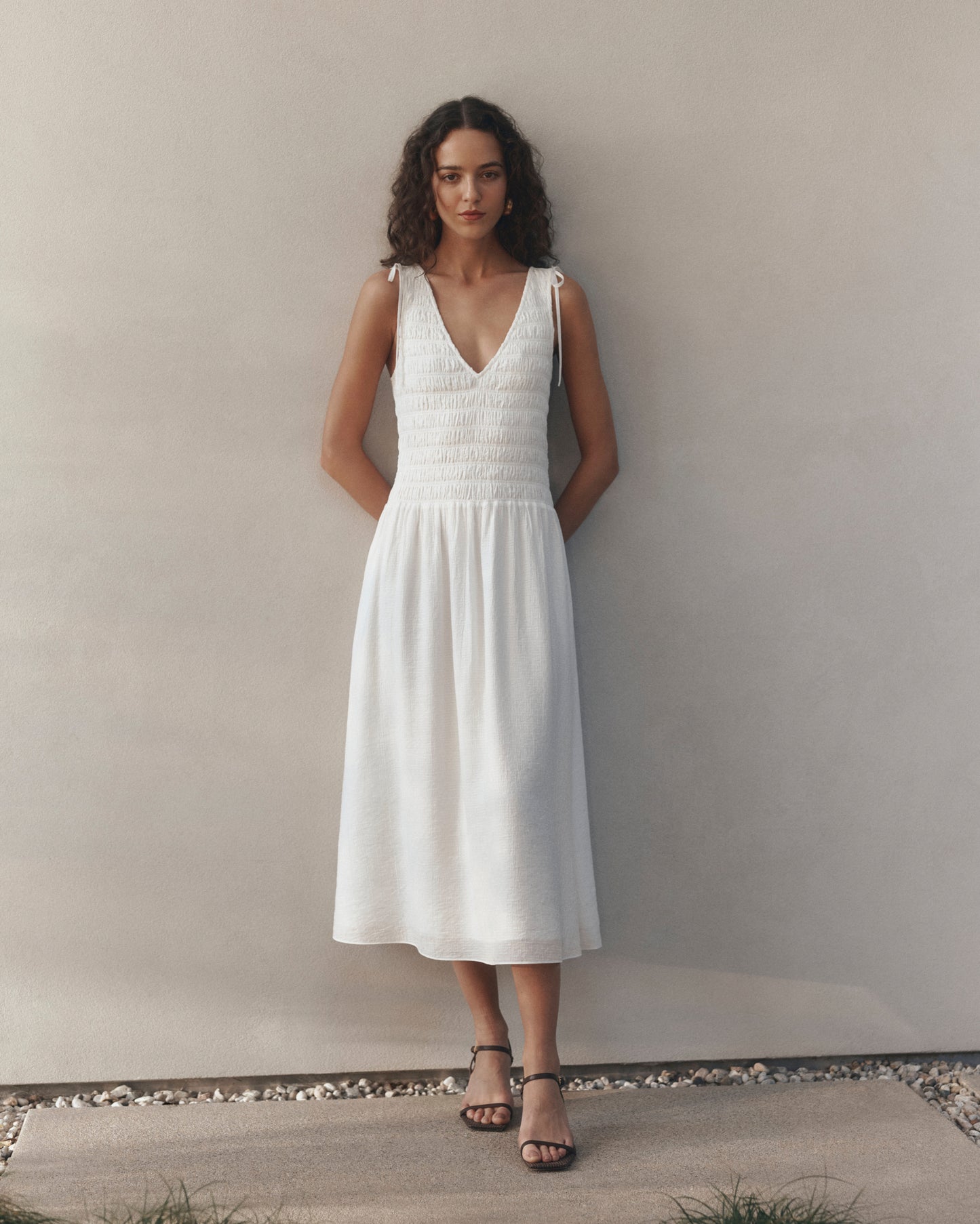 Woman wearing a white dress against a plain background