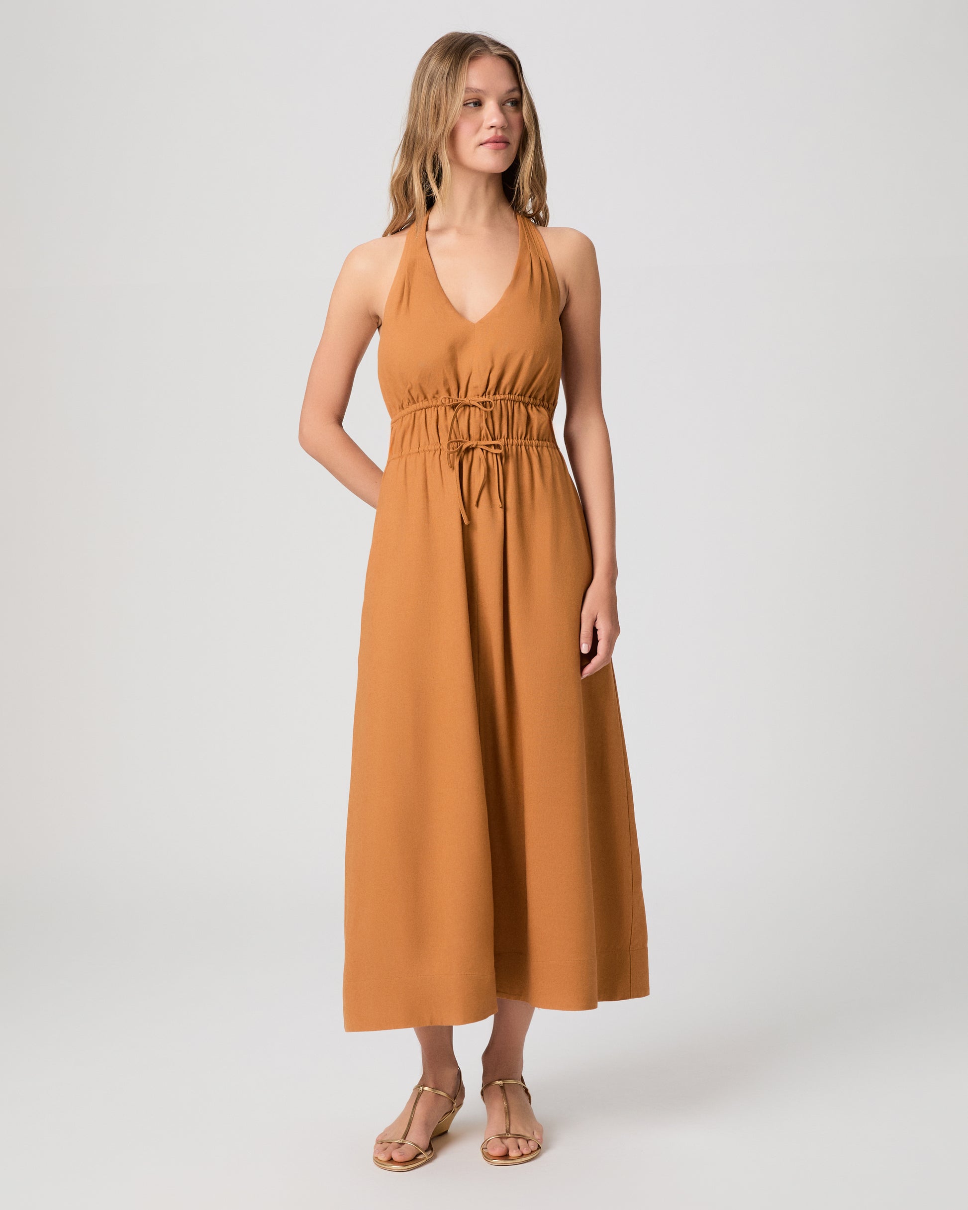 Woman wearing a mustard yellow dress on a white background