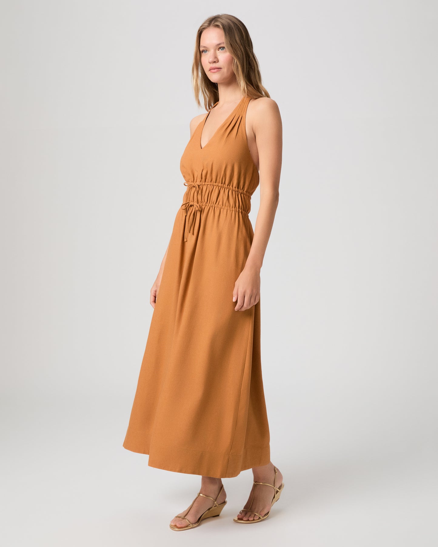 Woman wearing a mustard yellow dress on a white background