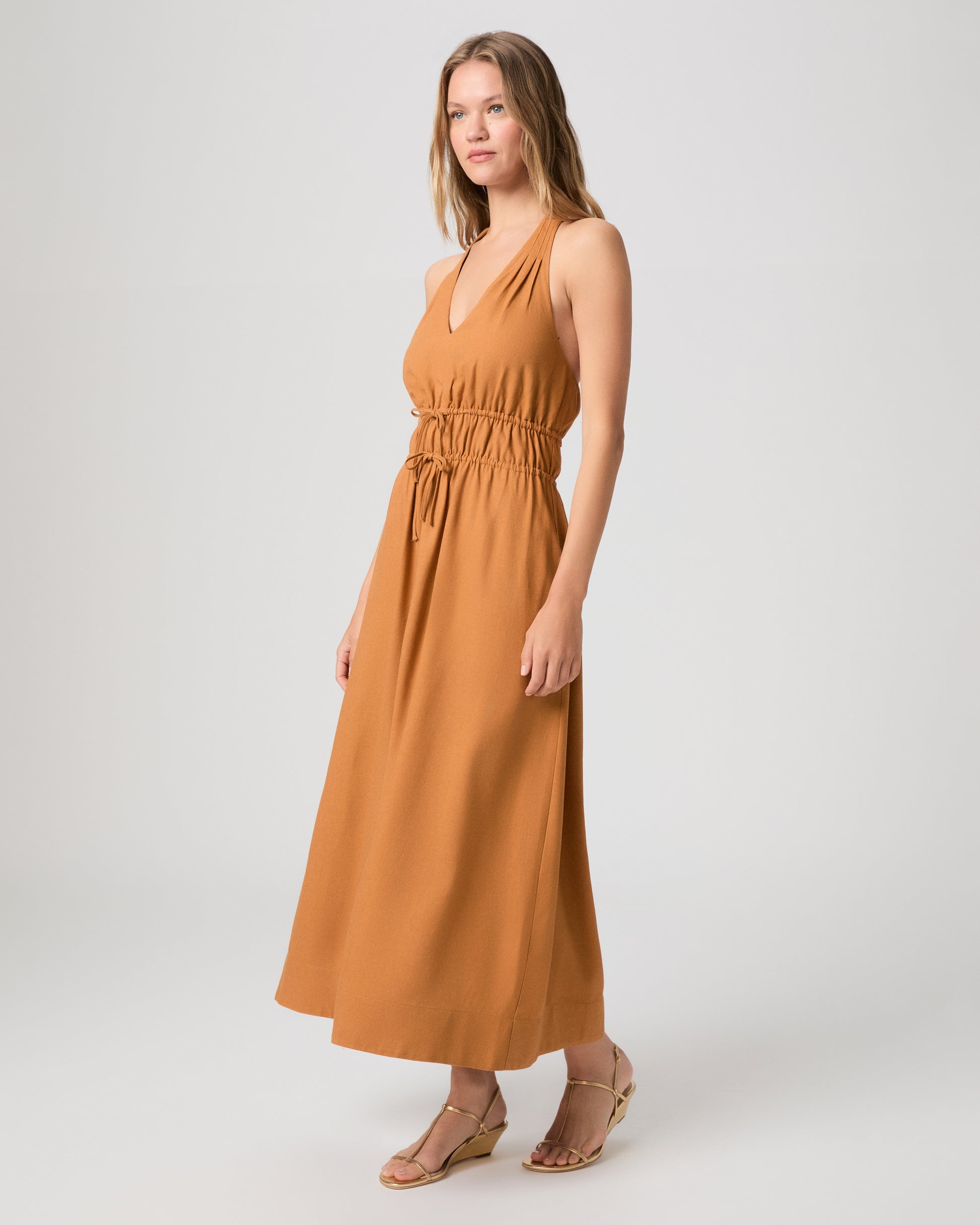 Woman wearing a mustard yellow dress on a white background