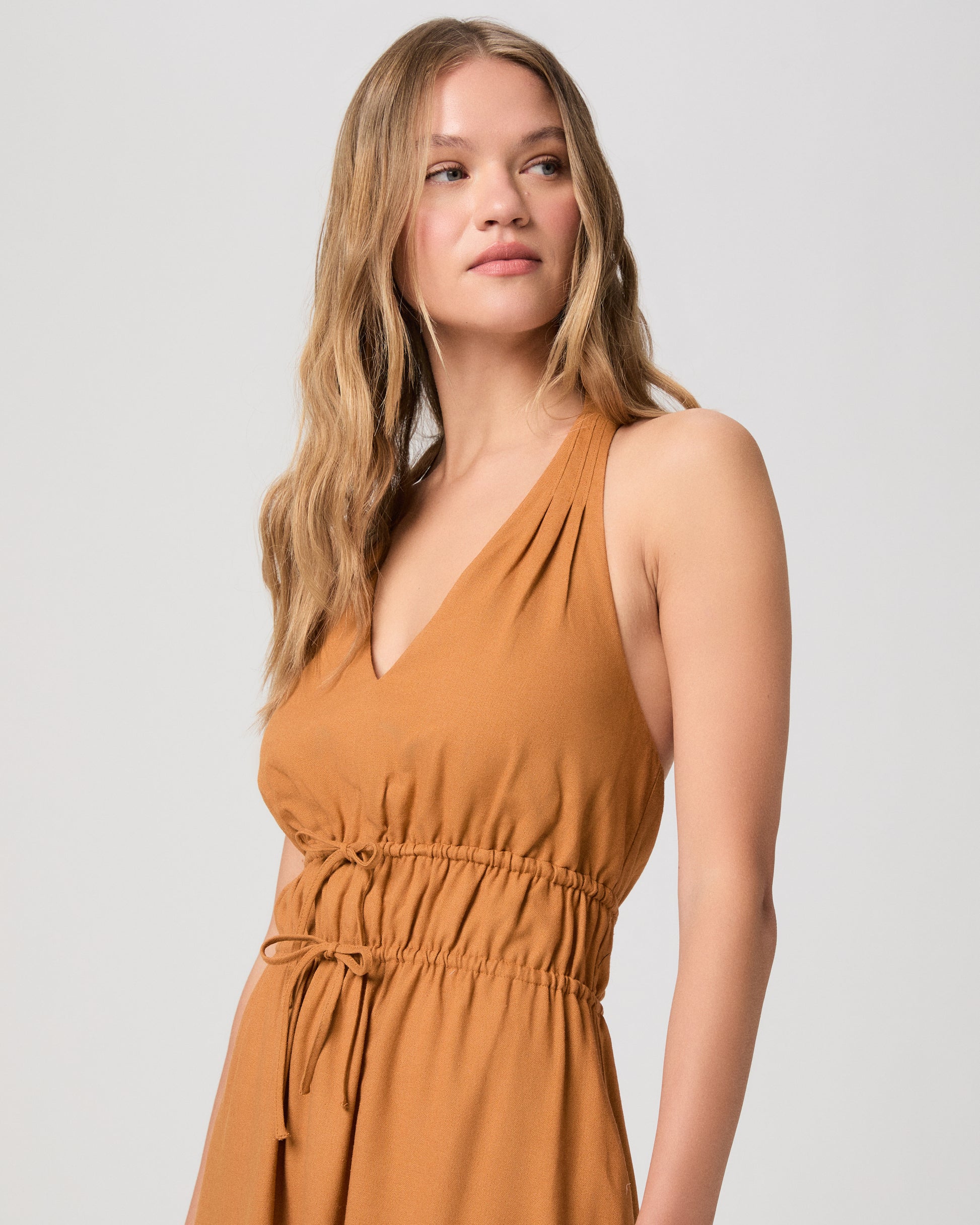 Woman wearing a mustard yellow dress on a white background