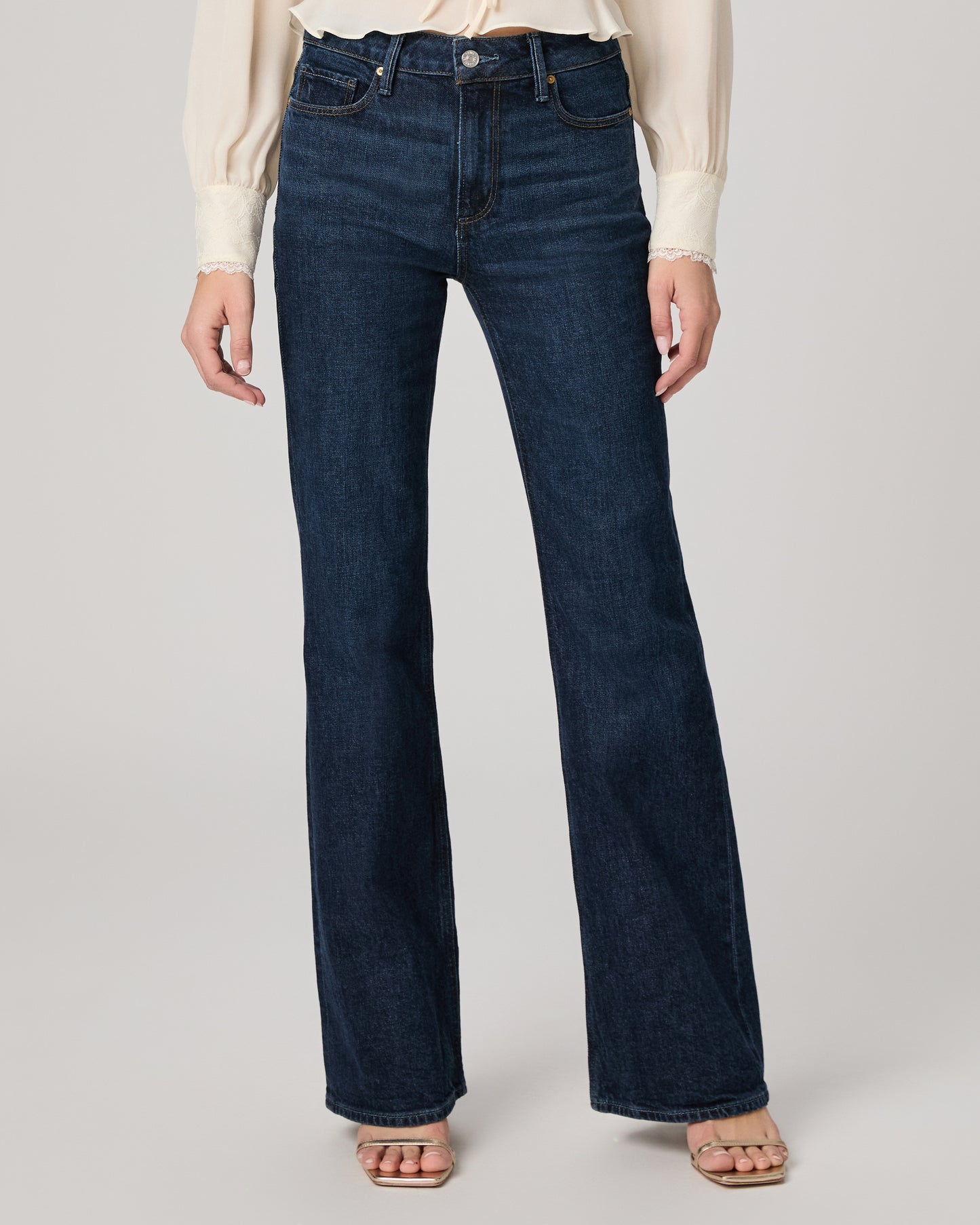 Dark blue jeans worn by a person on a light gray background
