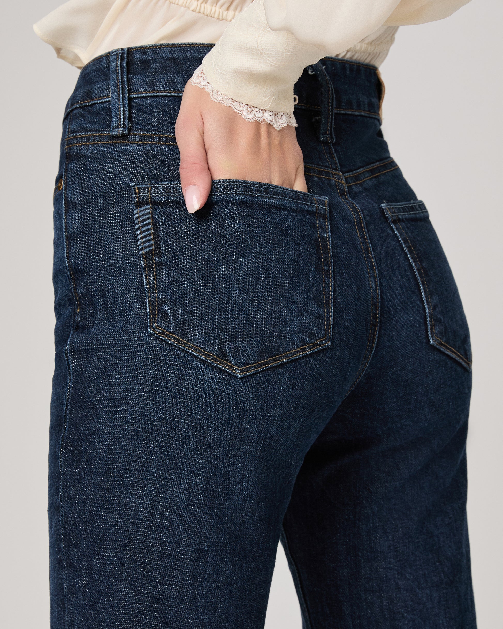 Close-up of dark blue jeans with a plain background