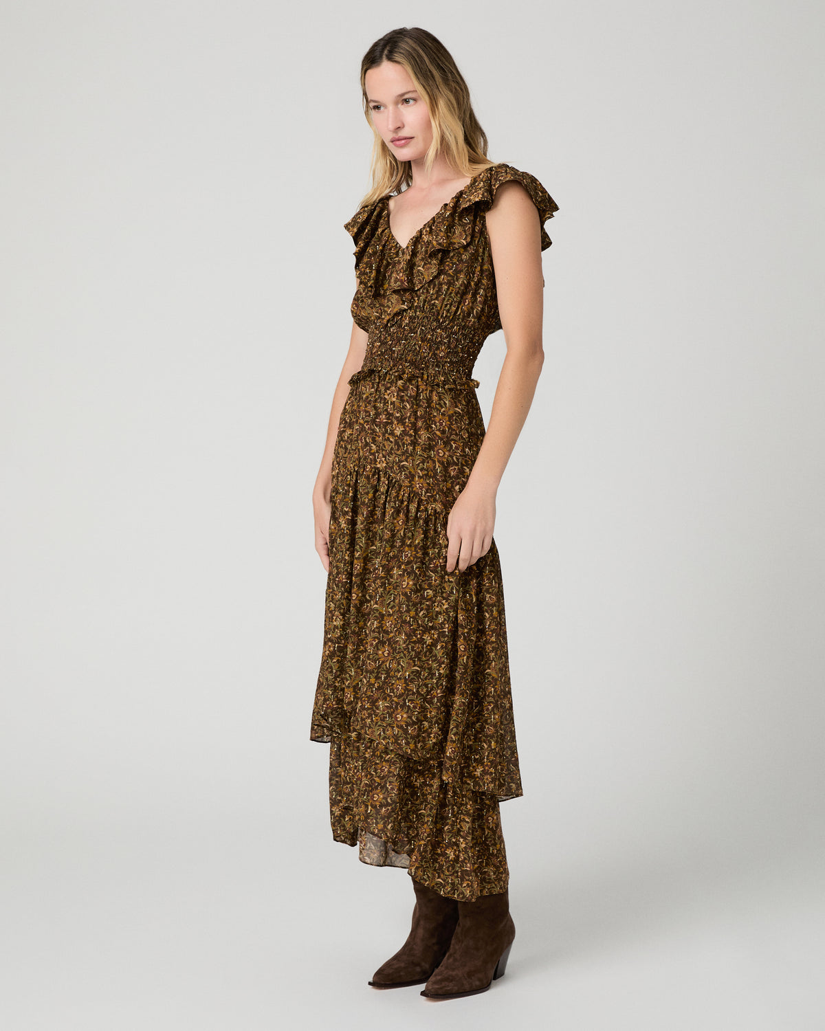 Women wearing a flower printed brown dress and paired with brown boots against a white background