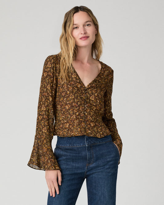 Women wearing a flower print blouse paired with blue jeans against a white background