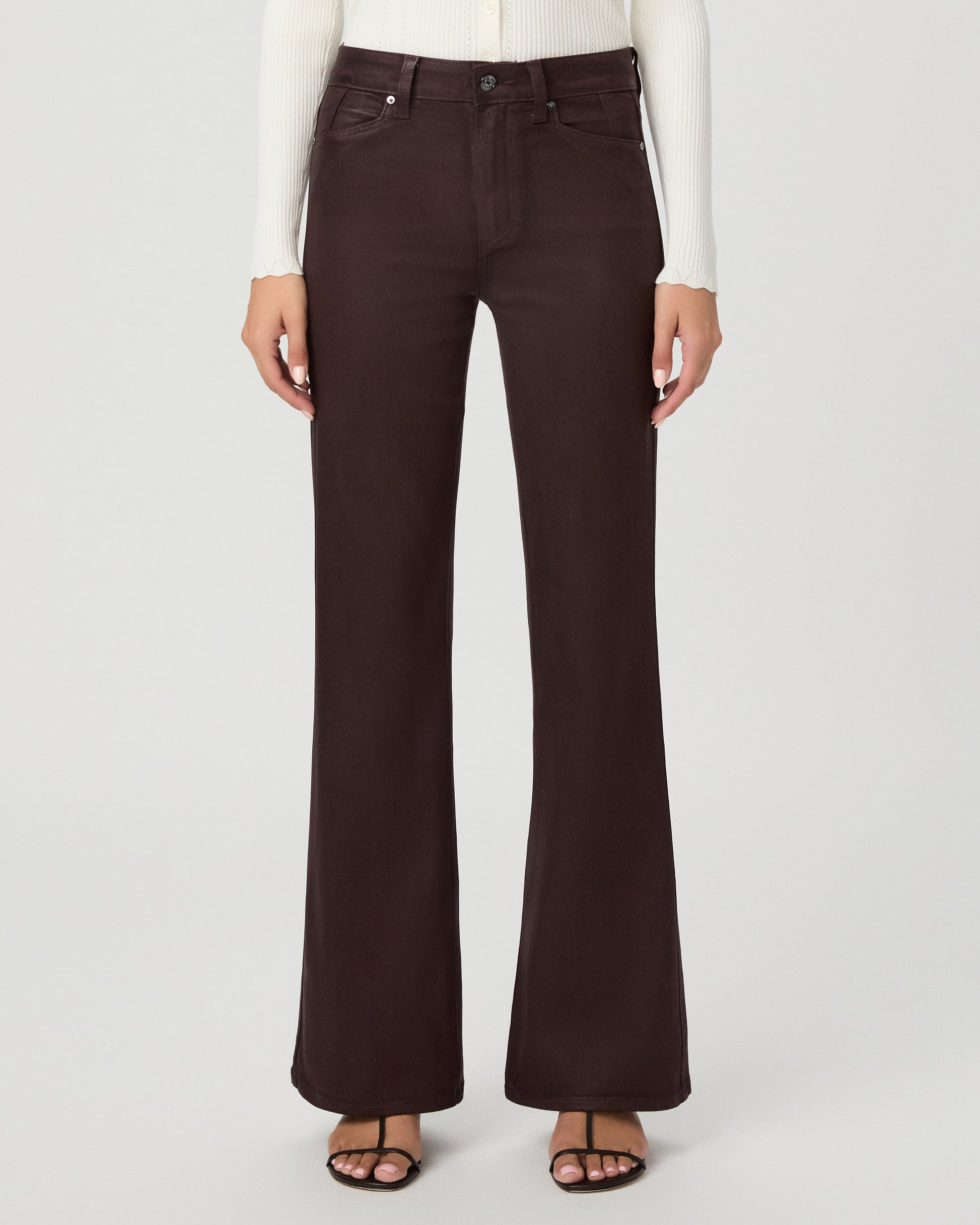 A woman modeling a cream long-sleeve knit cardigan with a V-neck and button front, paired with dark brown wide-leg pants, against a light gray studio background.