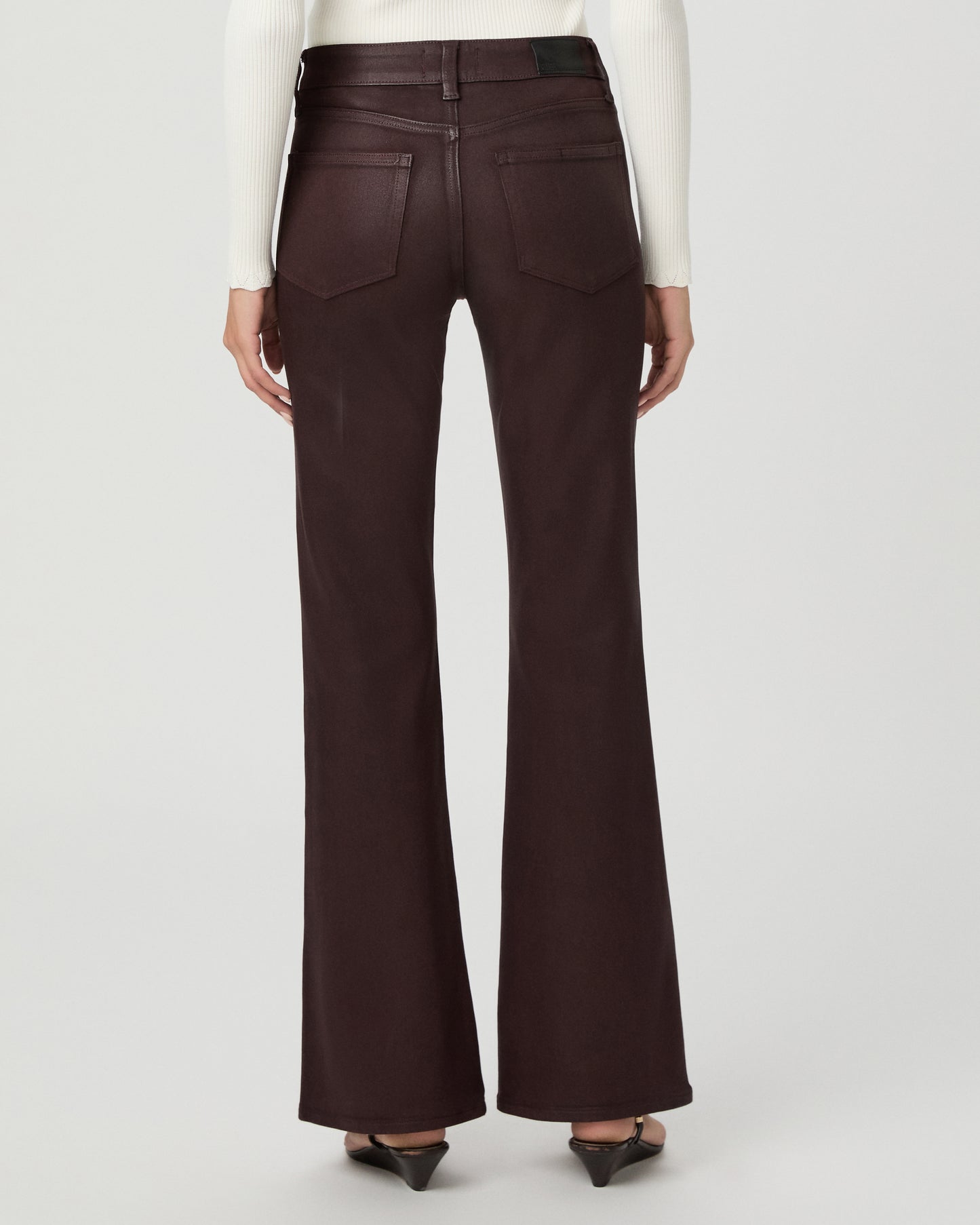A woman modeling a cream long-sleeve knit cardigan with a V-neck and button front, paired with dark brown wide-leg pants, against a light gray studio background.