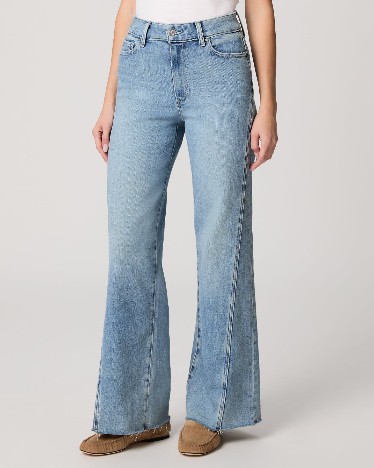 Light blue flared jeans worn by a person on a white background