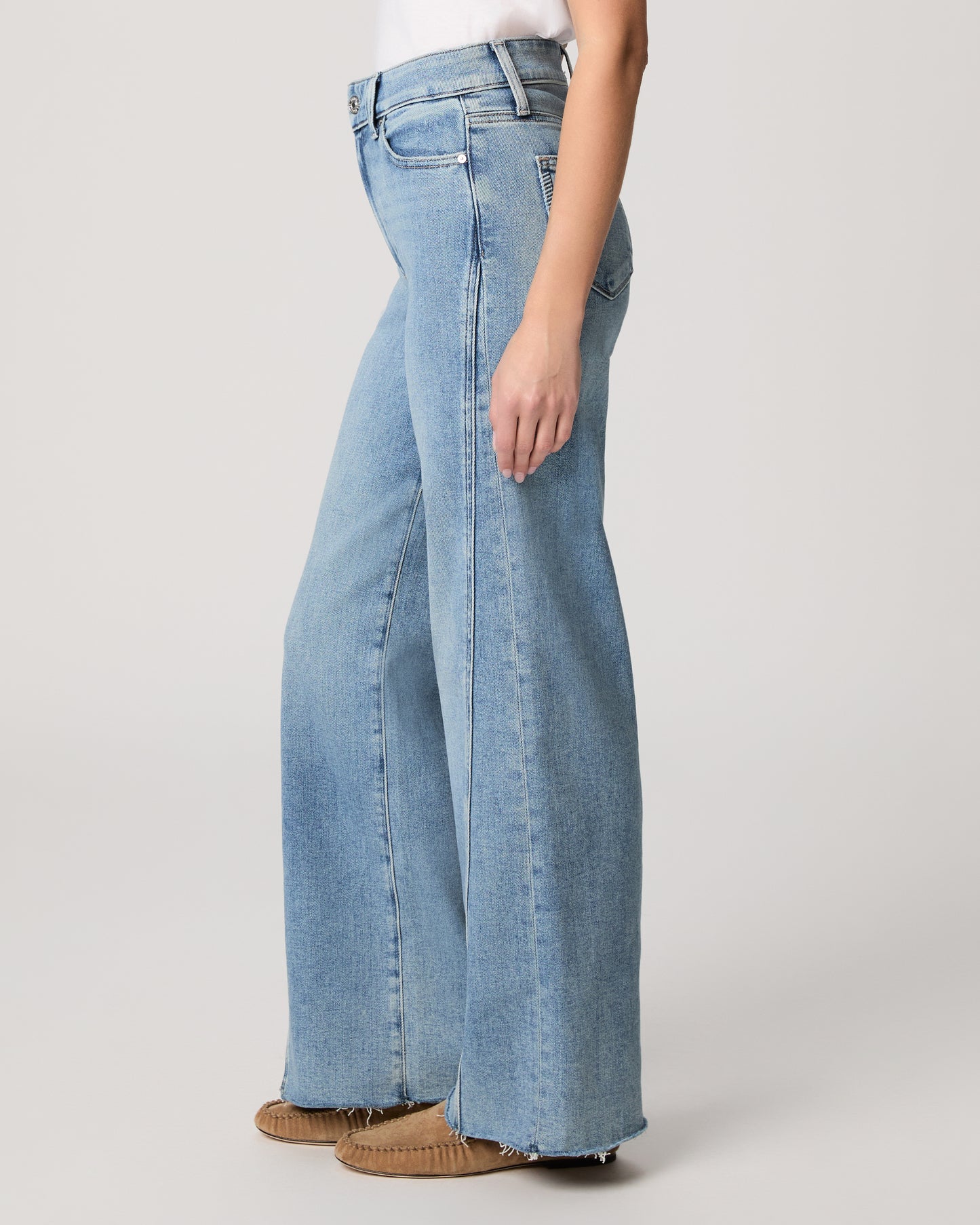 Light blue jeans worn by a person on a plain background
