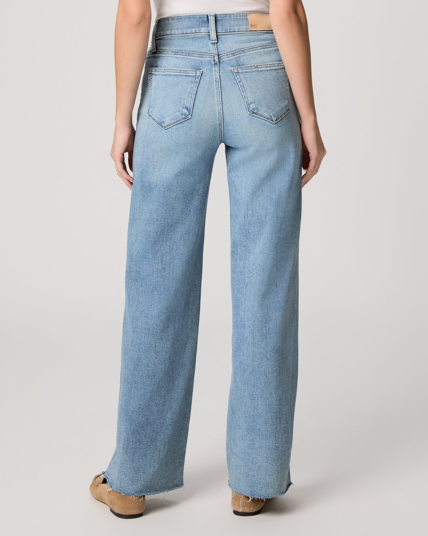 Light blue jeans worn by a person on a white background