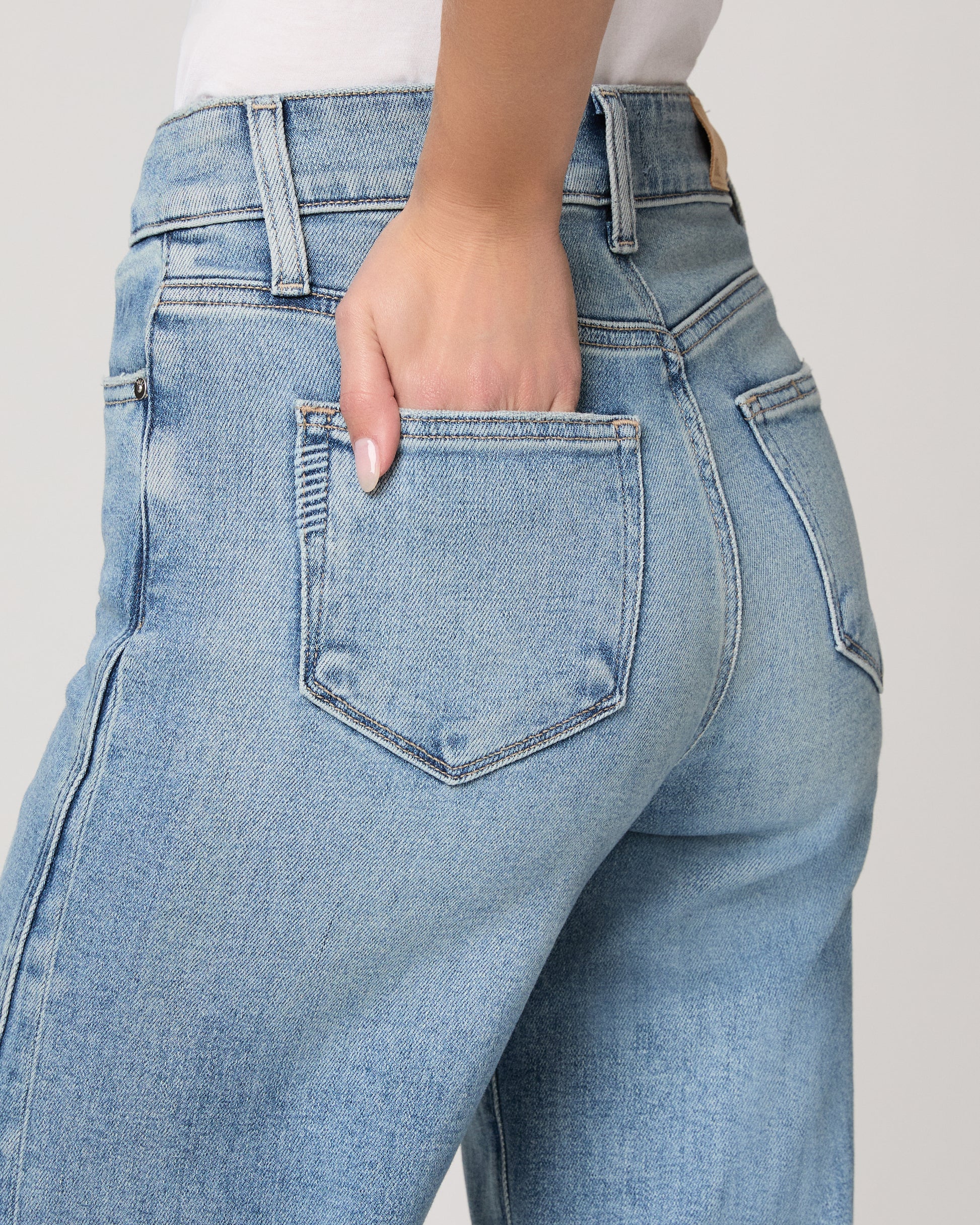 Light blue jeans worn by a person on a plain background