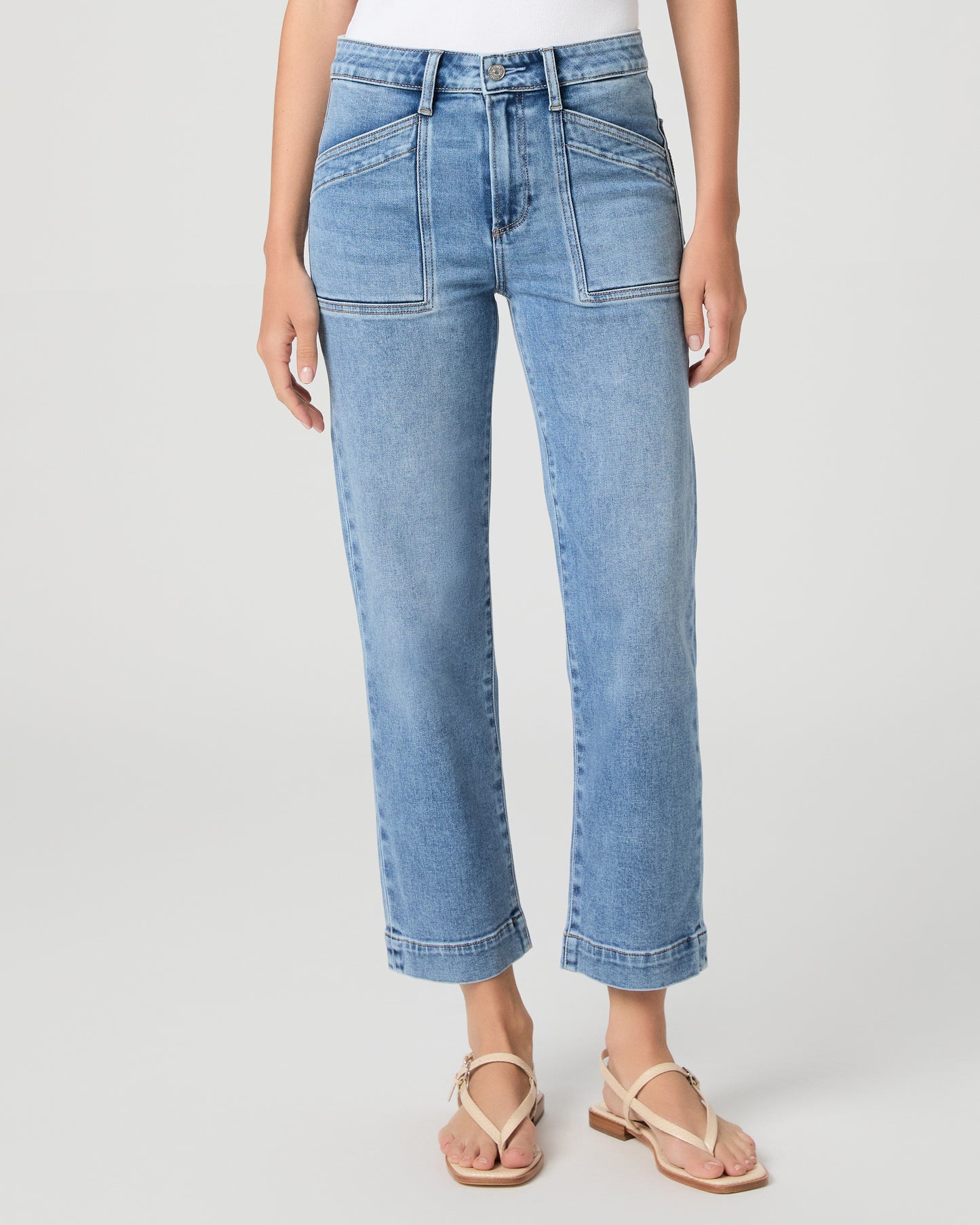 Woman wearing a maroon top and blue jeans on a white background