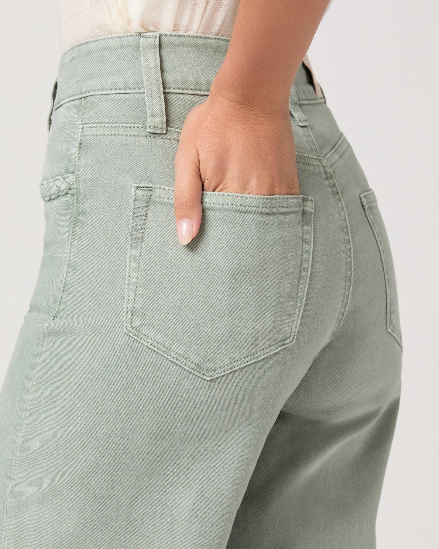 Model wearing a light green pant paired with a white top and brown sandals