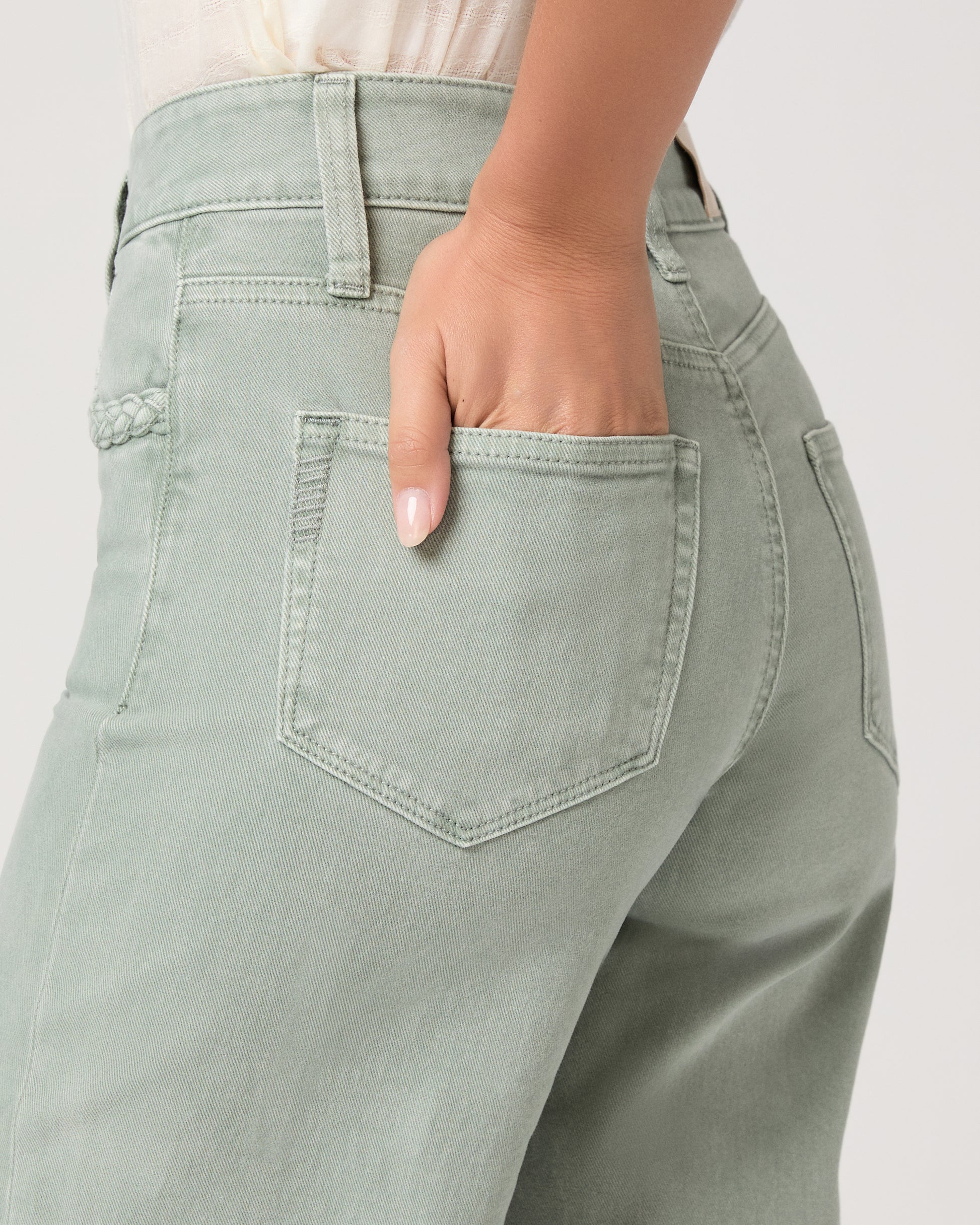 Model wearing a light green pant paired with a white top and brown sandals