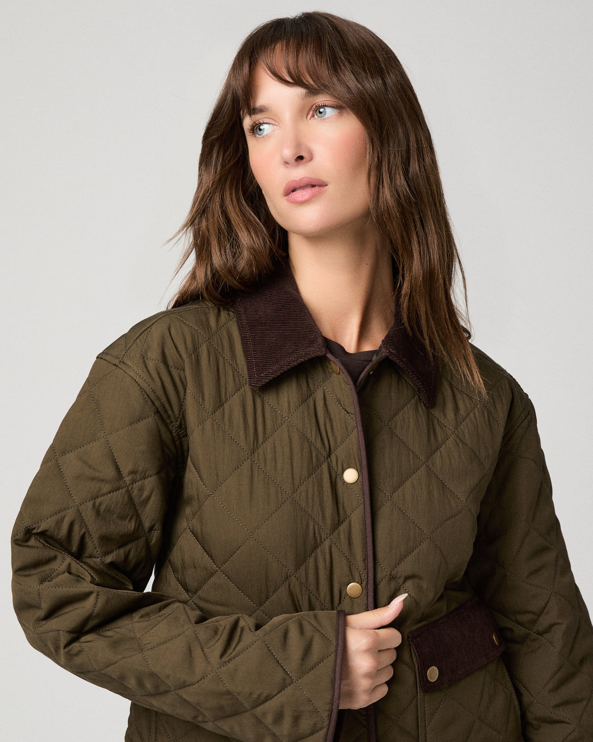 Woman wearing a green jacket against a white background