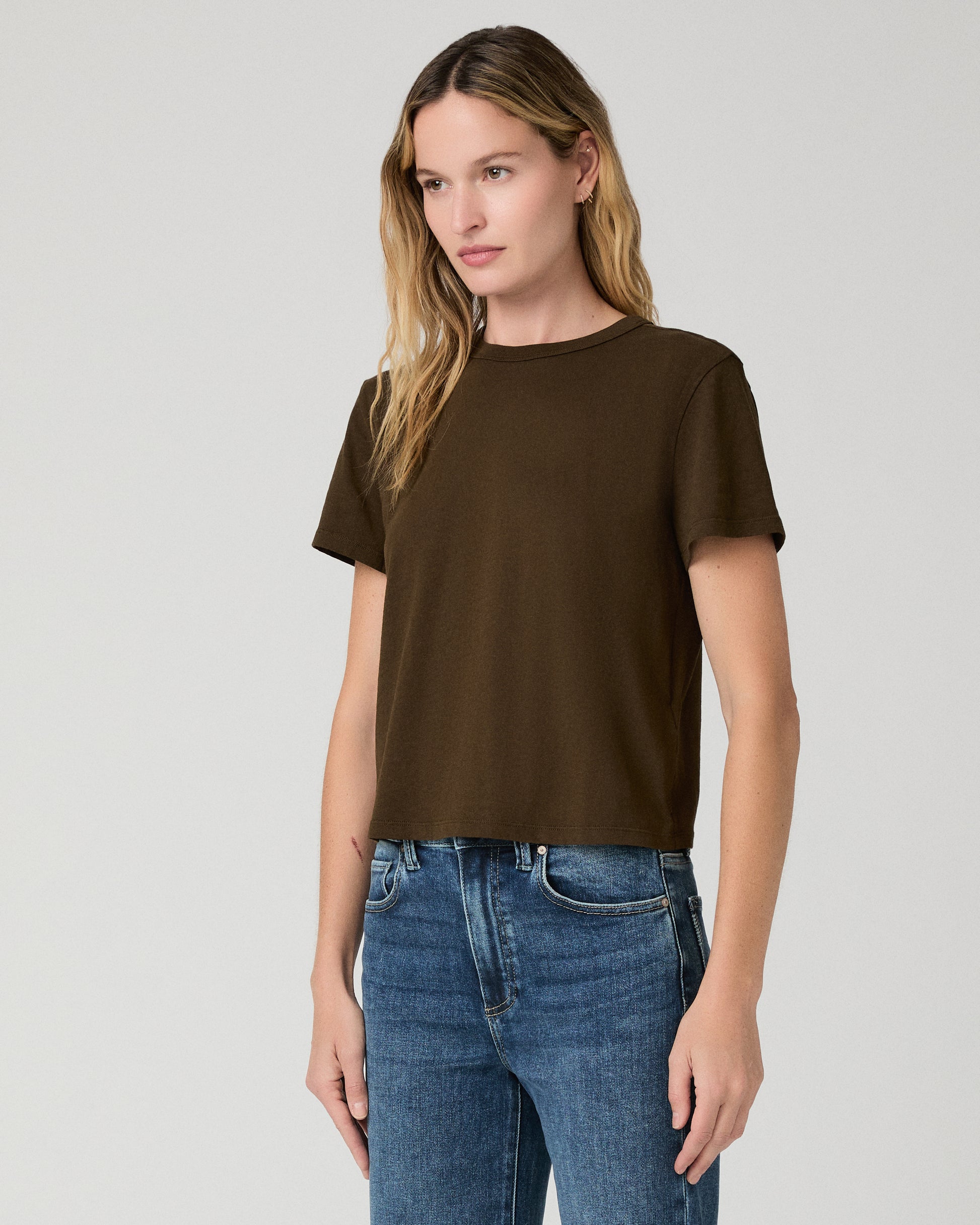 Women wearing green tee and blue jeans against a white background