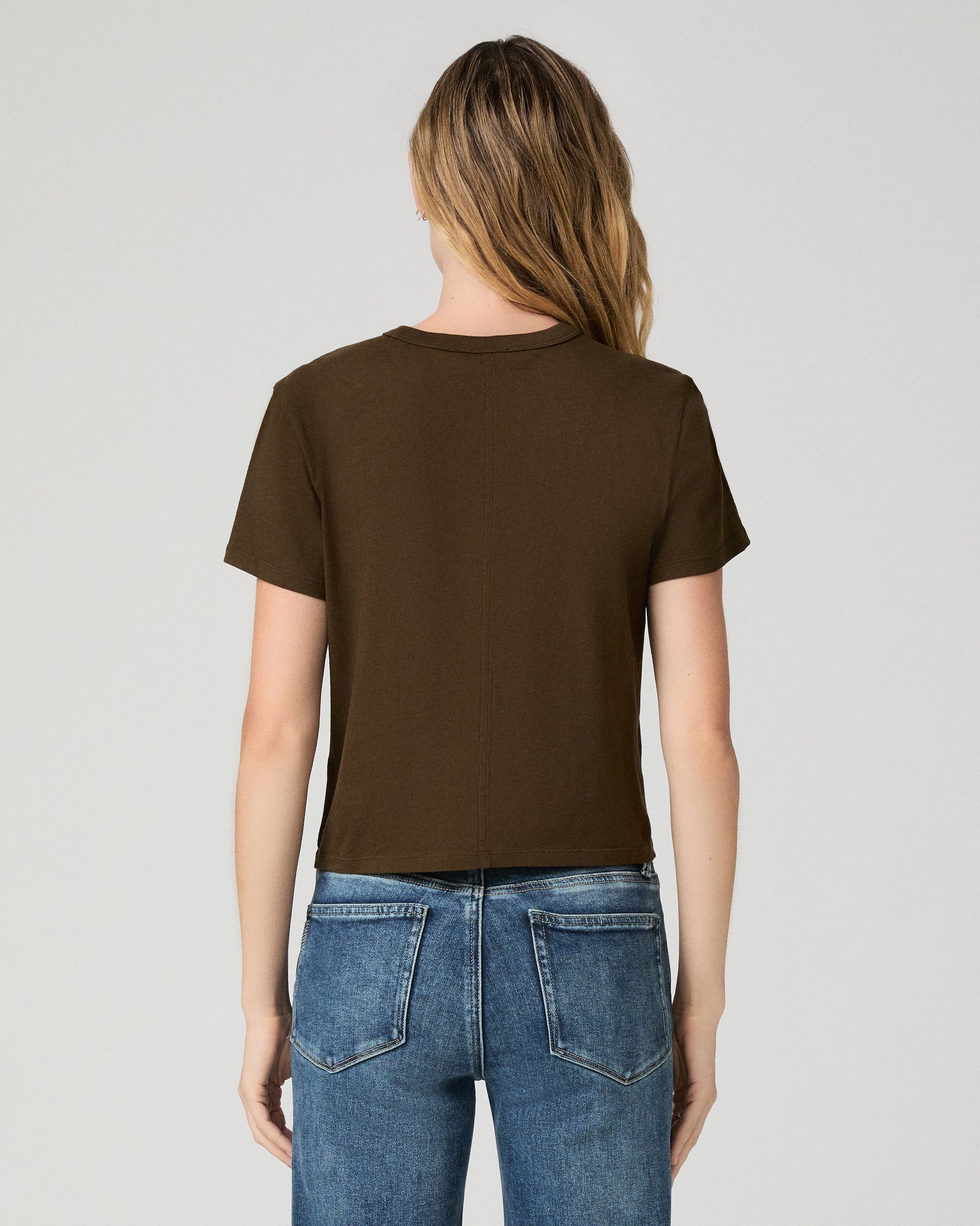 Women wearing green tee and blue jeans against a white background