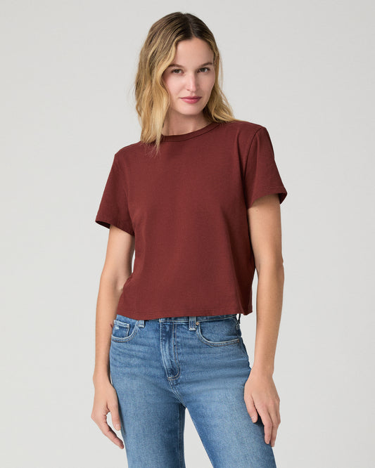 Women wearing red tee and blue jeans against a white background
