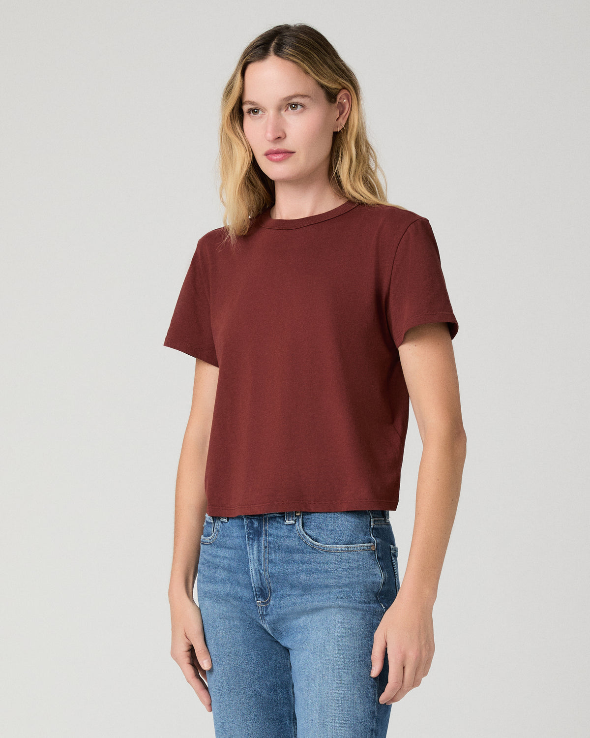 Women wearing red tee and blue jeans against a white background