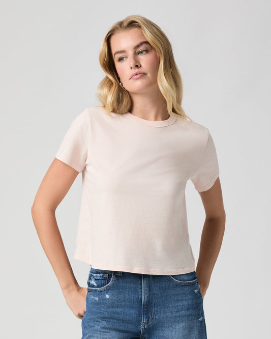 Rhodes Tee in Whisper Pink, a light pink crewneck tee; close-up of model facing forward with arms at her sides, worn with light blue jeans