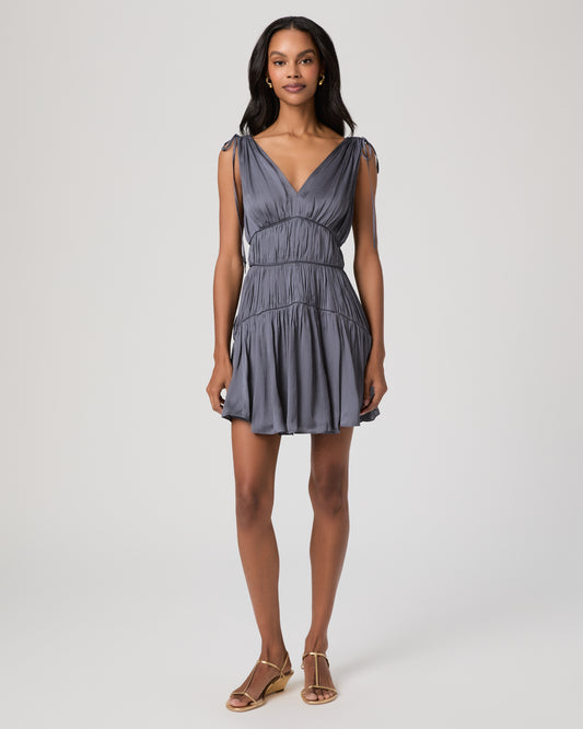 Women wearing a gray mini dress paired with gold sandals against a white background