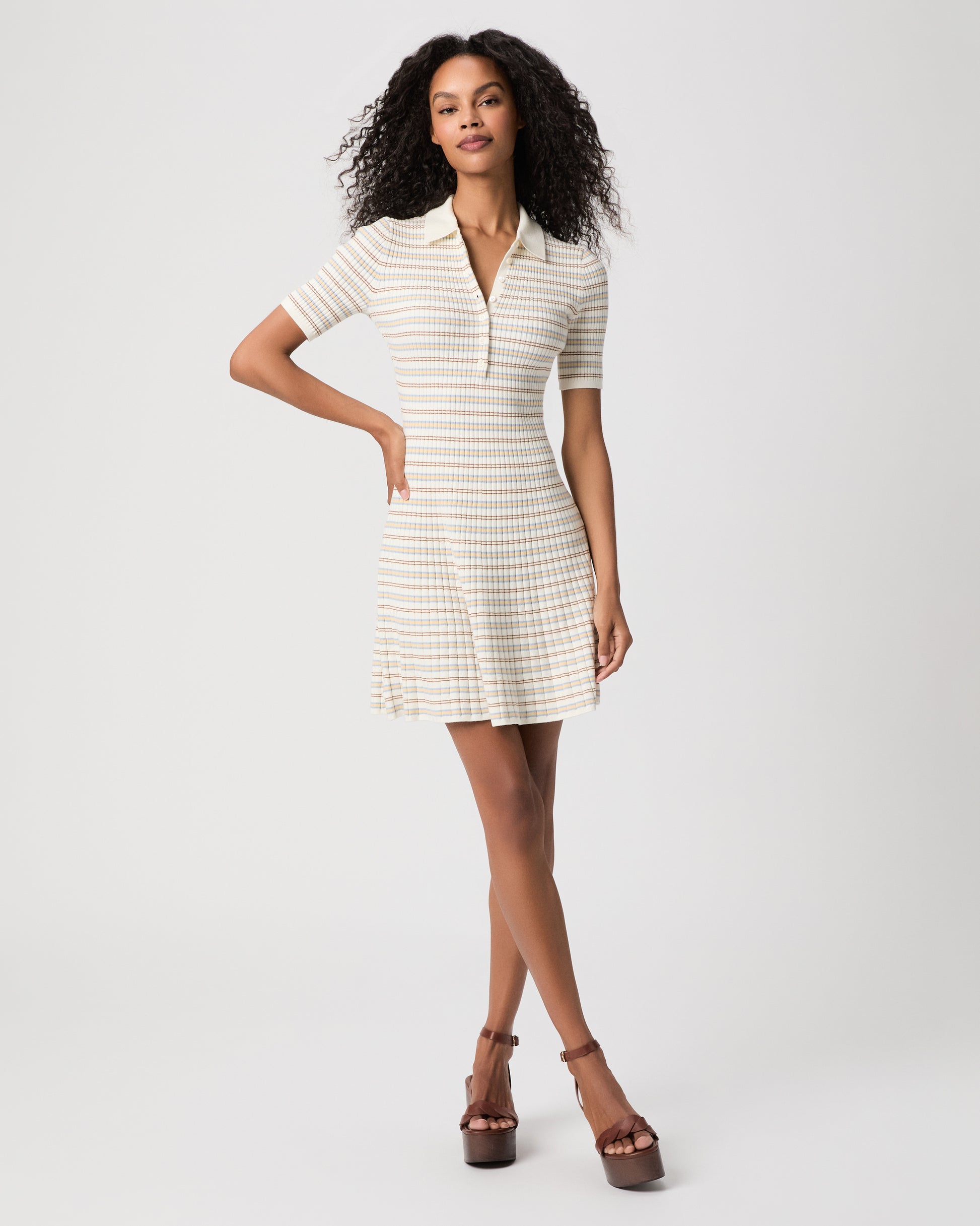 women wearing a mini white stripped dress with brown heels against a white background 