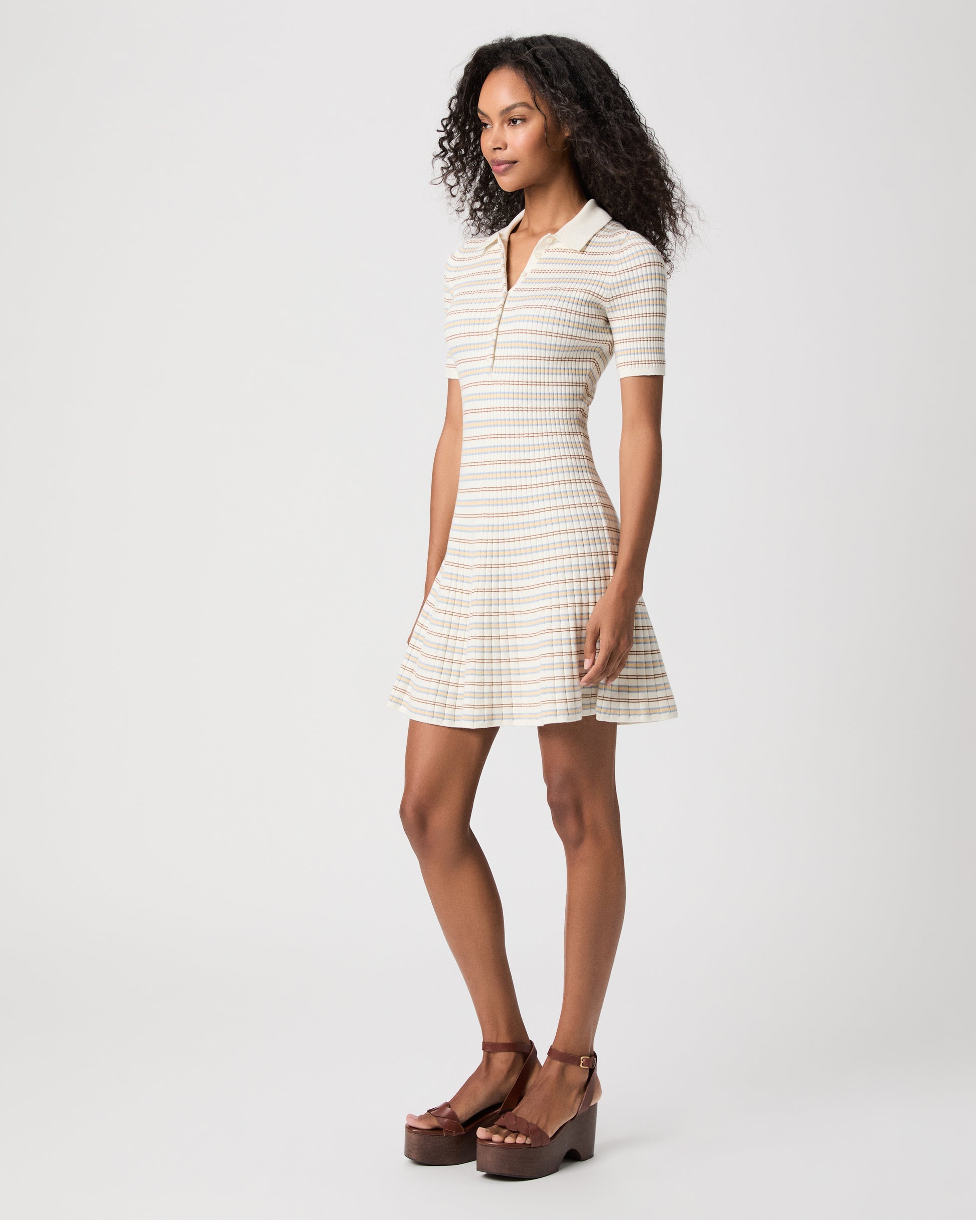 women wearing a mini white stripped dress with brown heels against a white background 