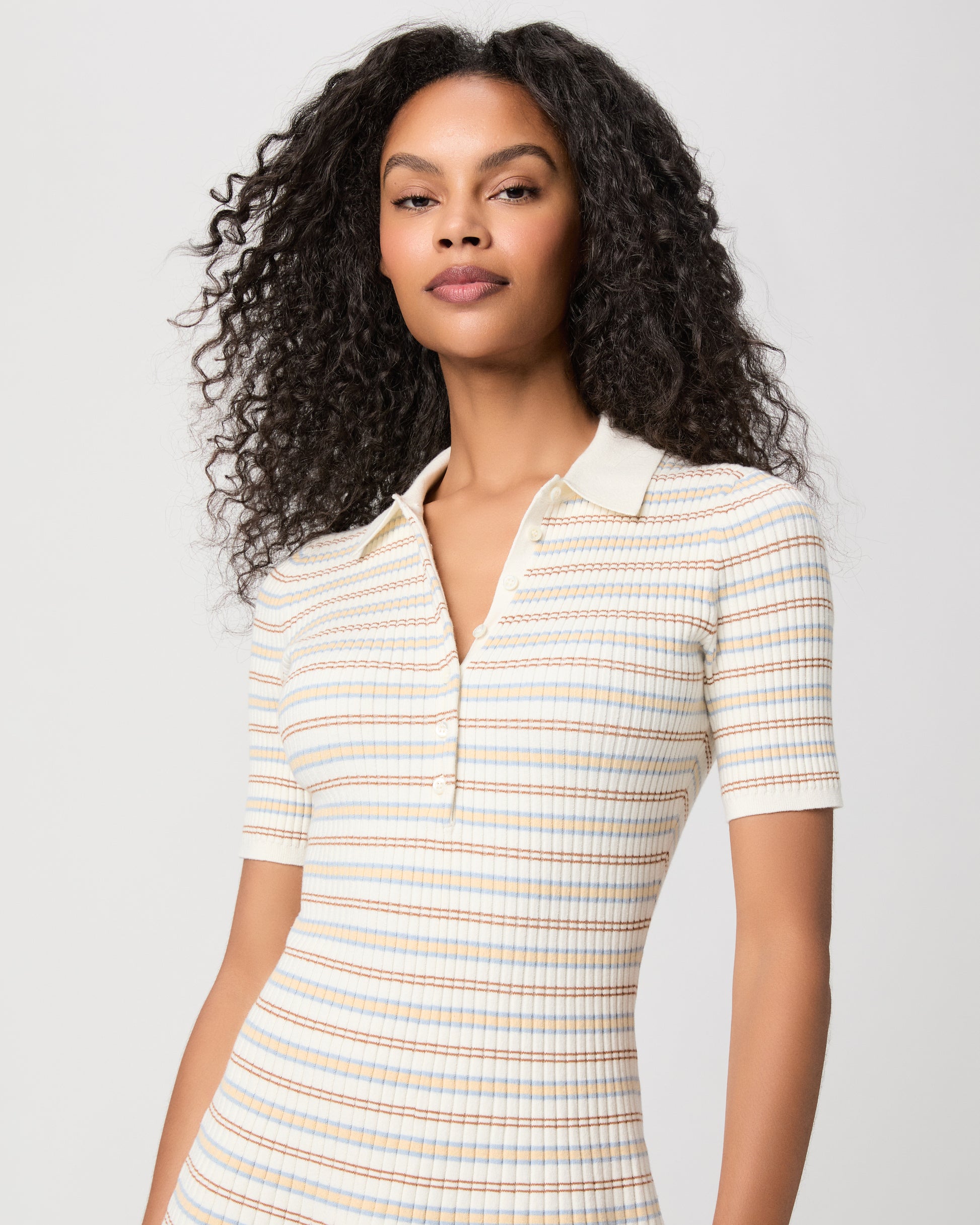 women wearing a mini white stripped dress with brown heels against a white background 
