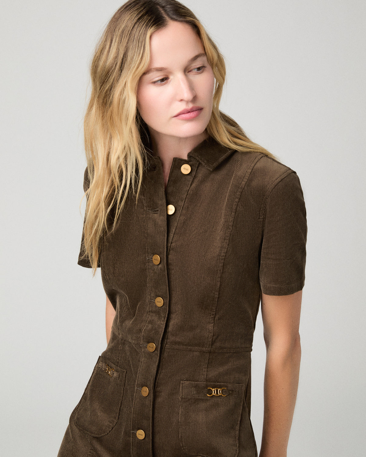 Women wearing a brown mini dress against a white background