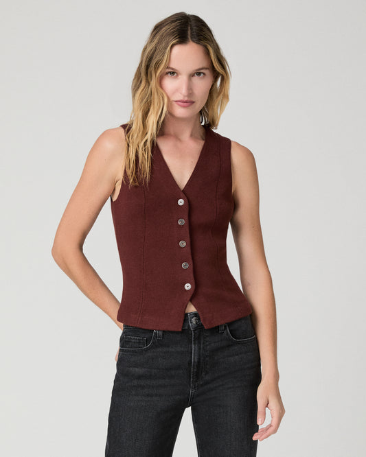 Women wearing a burgundy vest top paired with black jeans against a white background