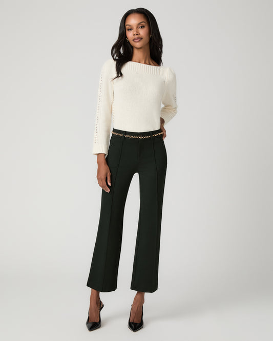 Full-length front view of a woman wearing an ivory knit sweater and dark spruce green cropped flare trousers with a tonal striped waistband, black pointed-toe pumps.