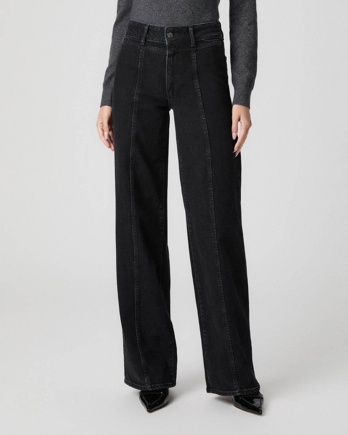 Front view from the waist down of the Sasha Wide Leg Jean in Downtown Noir black, showing the front seams, worn with black pointed heels