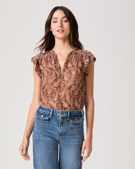 Model wearing a printed brown short sleeve top paired with medium wash denim jeans