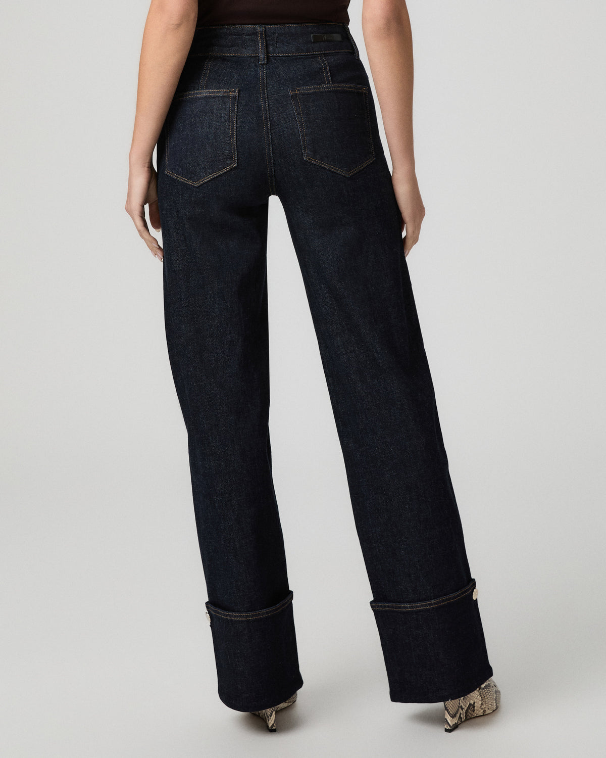 Back view of the Sasha Wide Leg Jean showing the dark indigo wash and cuffed hems with hardware
